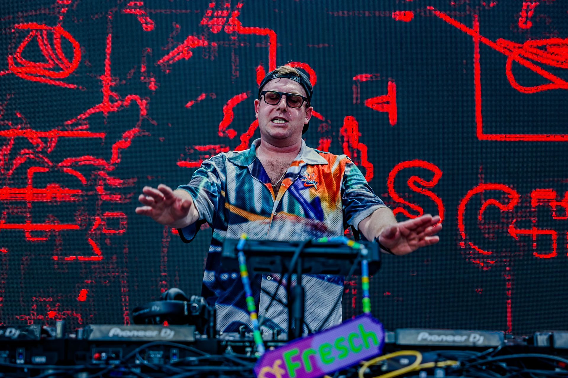 A man is playing a keyboard on a stage in front of a large screen.