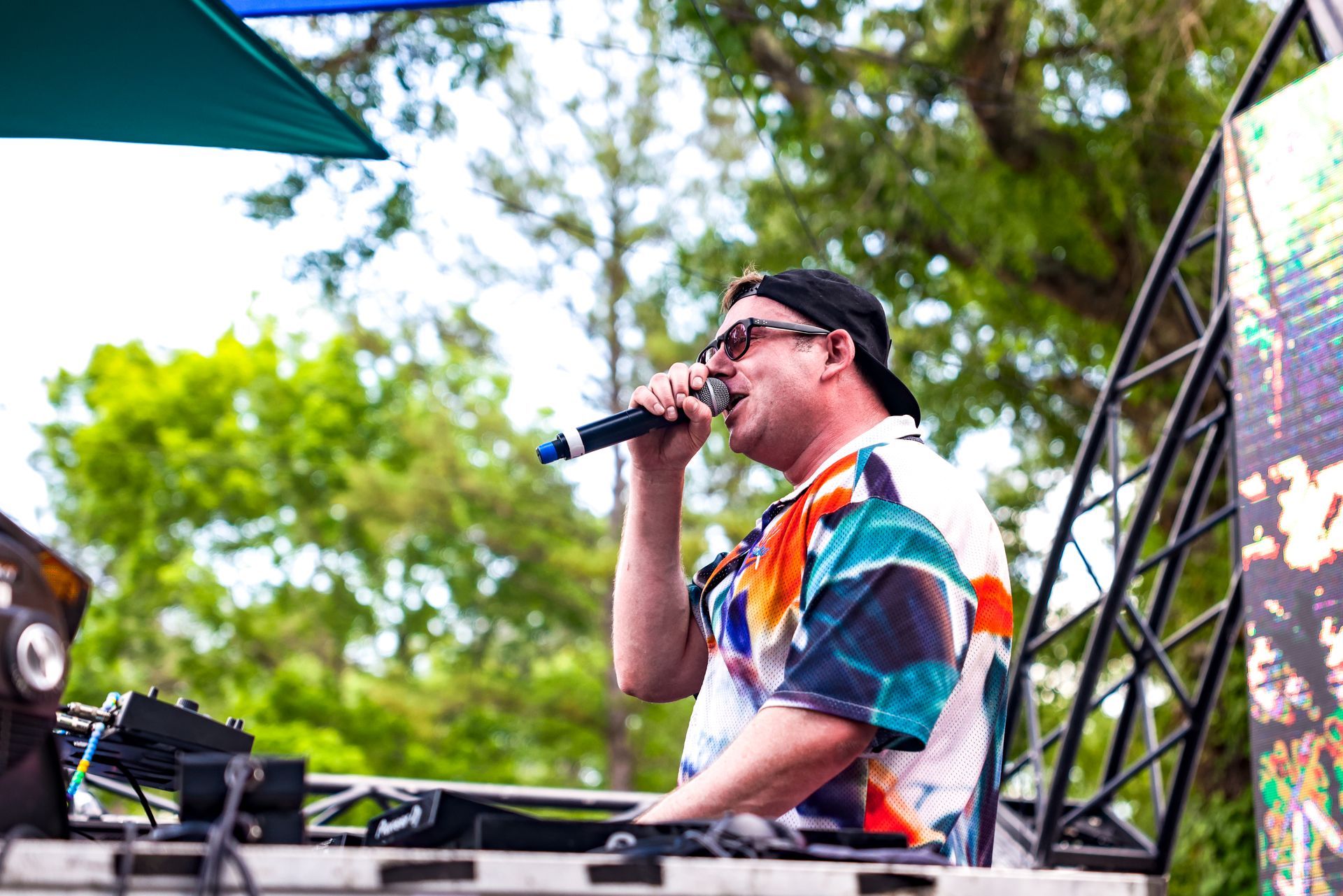 A man is singing into a microphone while sitting at a table.