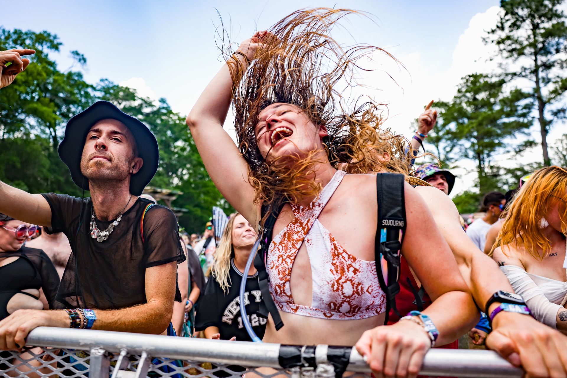 A group of people are standing in a crowd at a music festival.