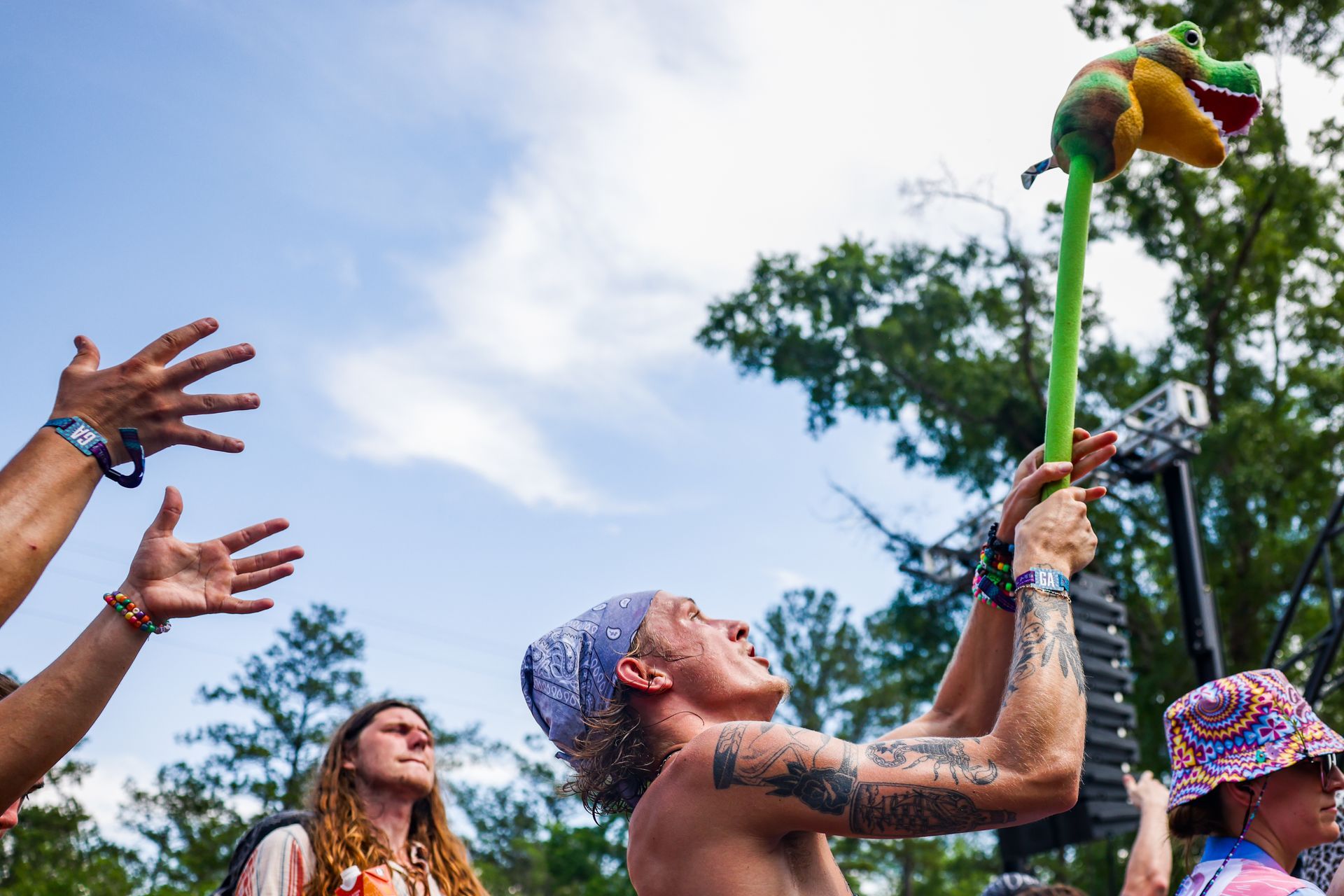 A man is throwing a stuffed animal into the air at a festival.