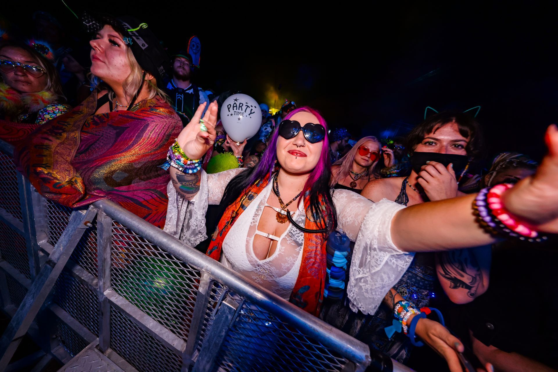A group of people are standing in a crowd at a concert.