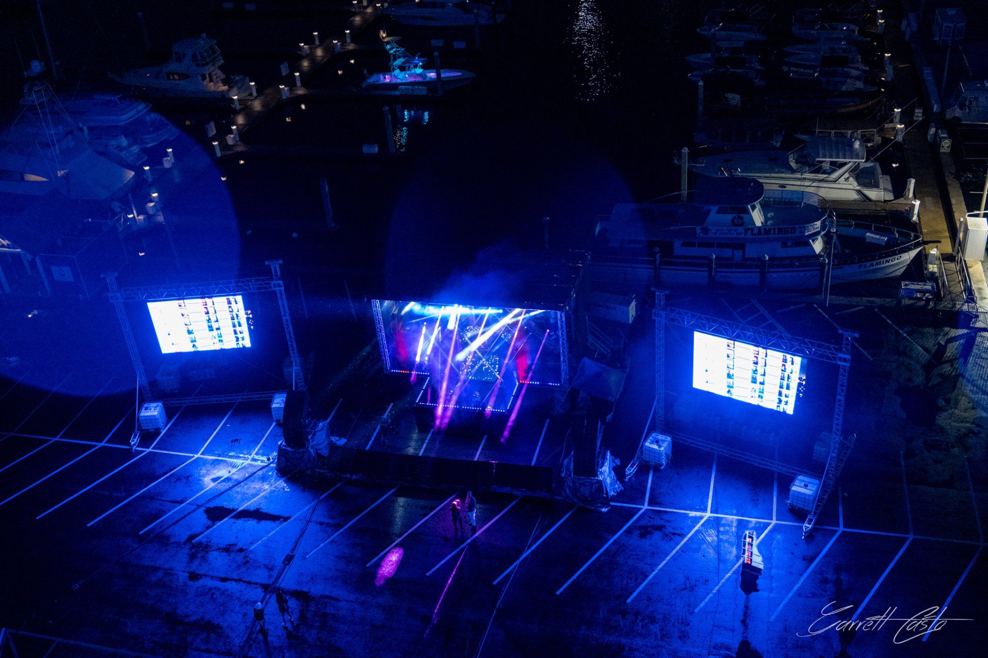 An aerial view of a concert in a parking lot at night.