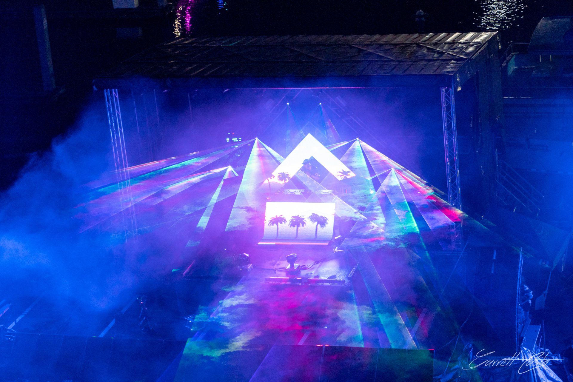 A stage with a mountain and palm trees projected on it.