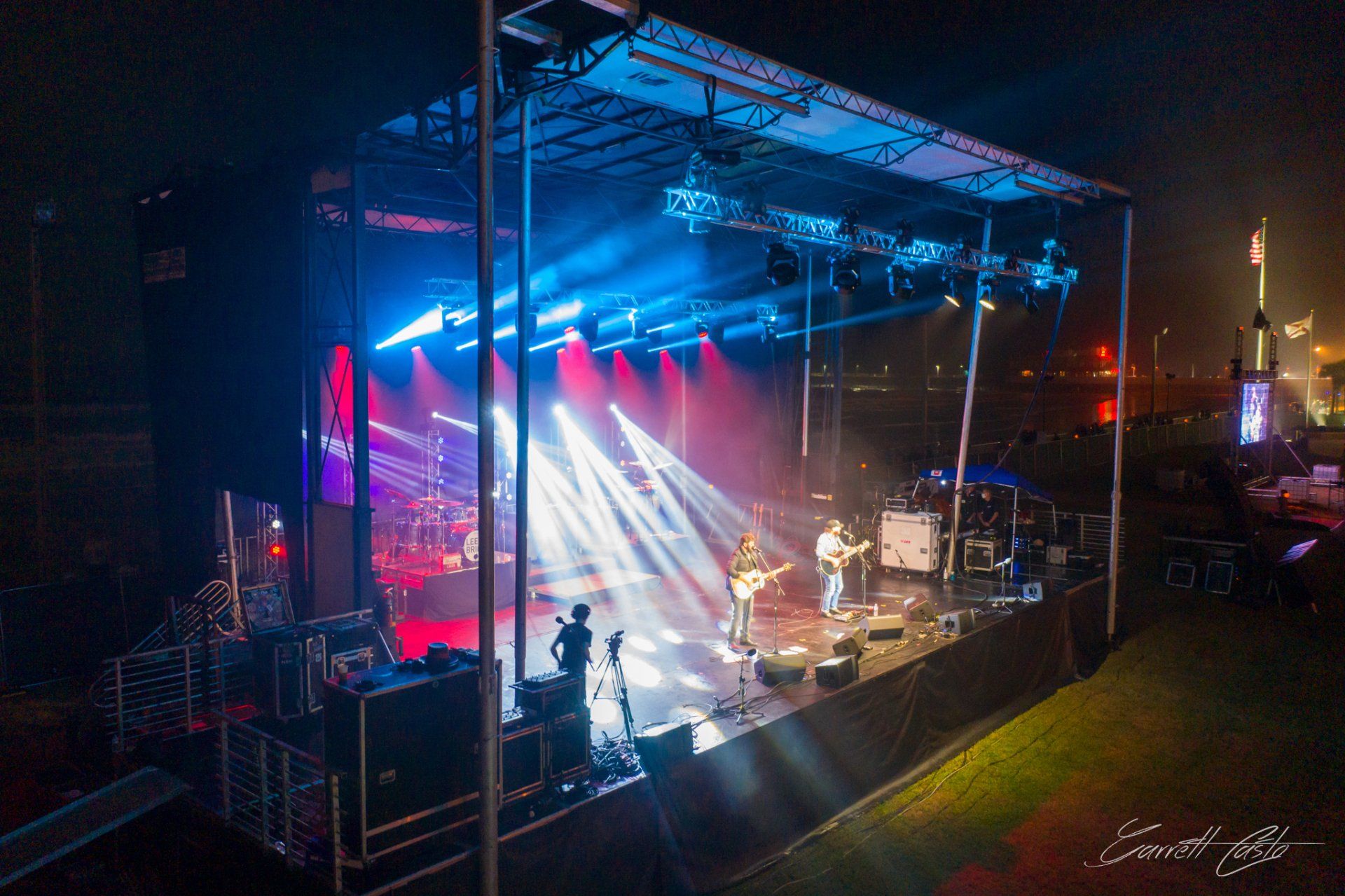 A group of people are playing instruments on a stage at night.