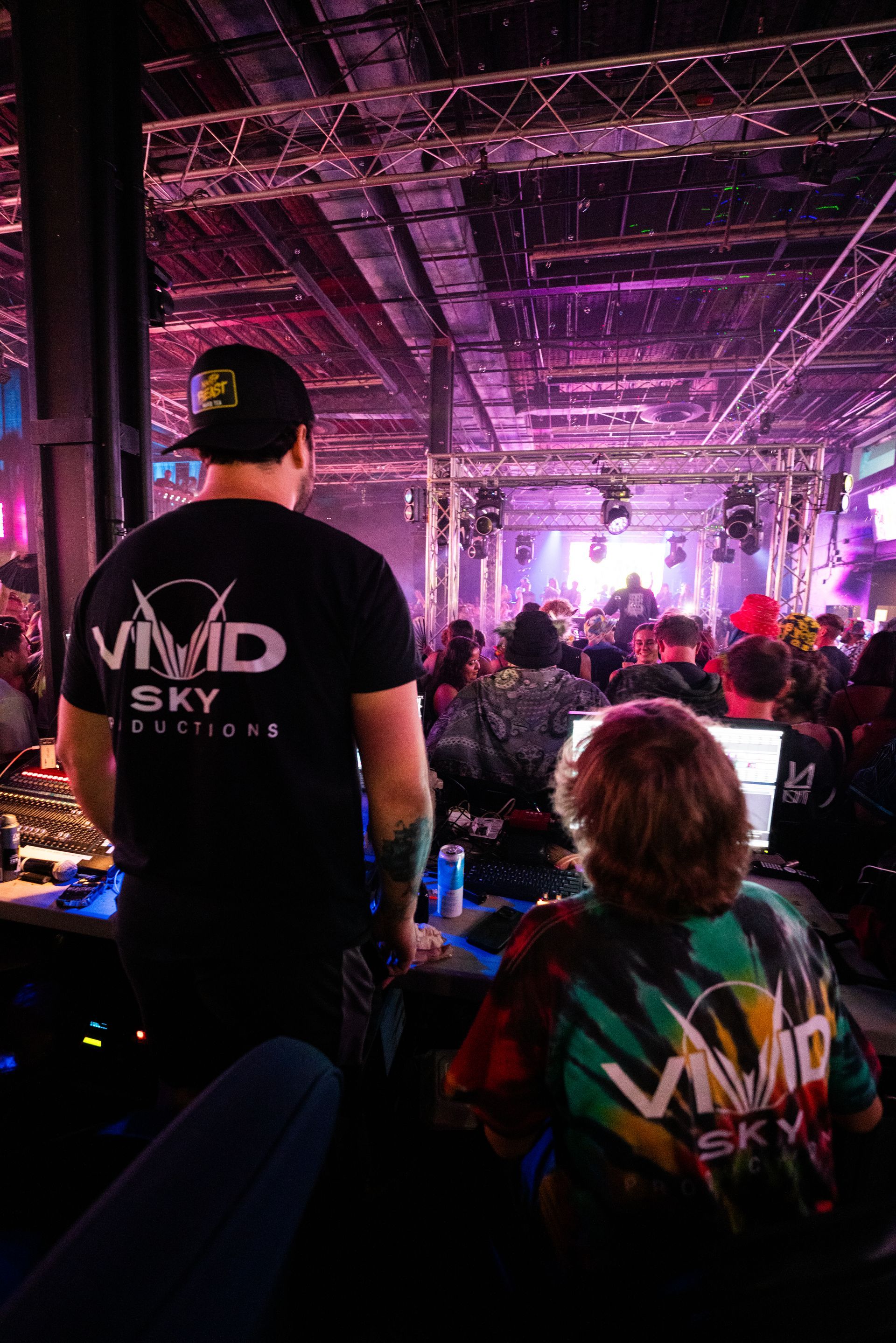 A man is standing in front of a crowd of people at a concert.
