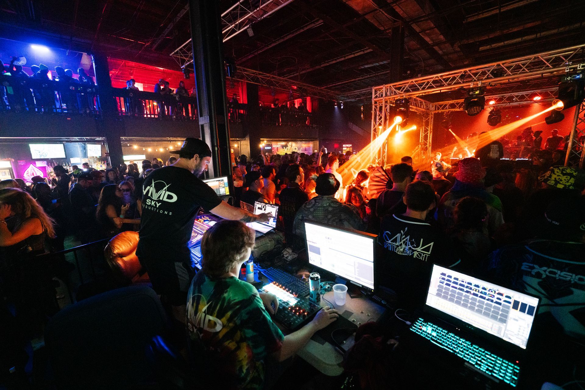 A crowd of people are gathered in a large room at a concert.