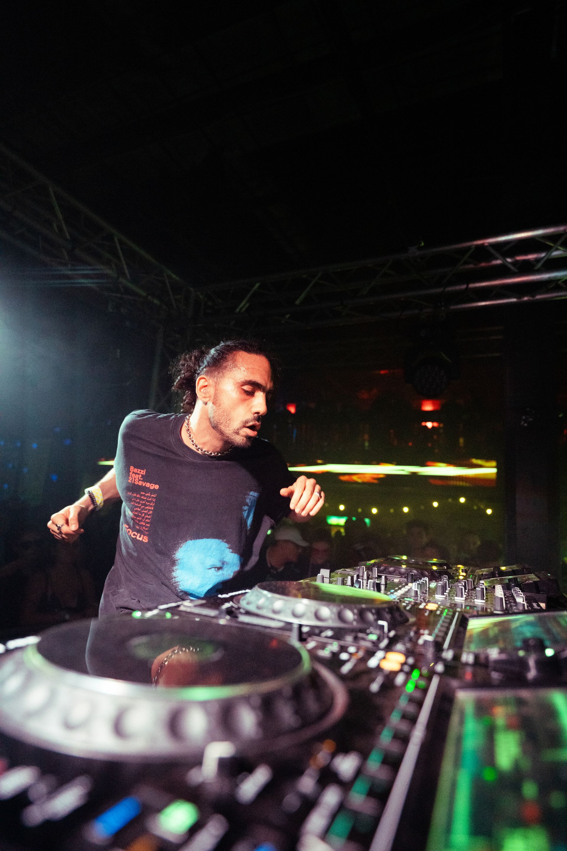 A man is playing a dj set in a dark room.