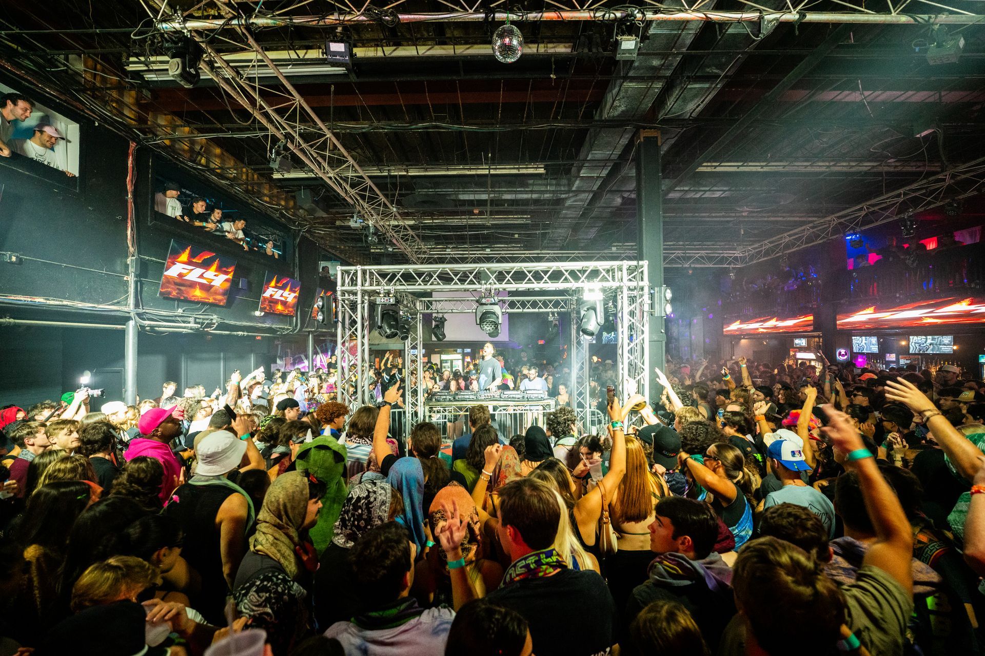 A large crowd of people are dancing at a concert.