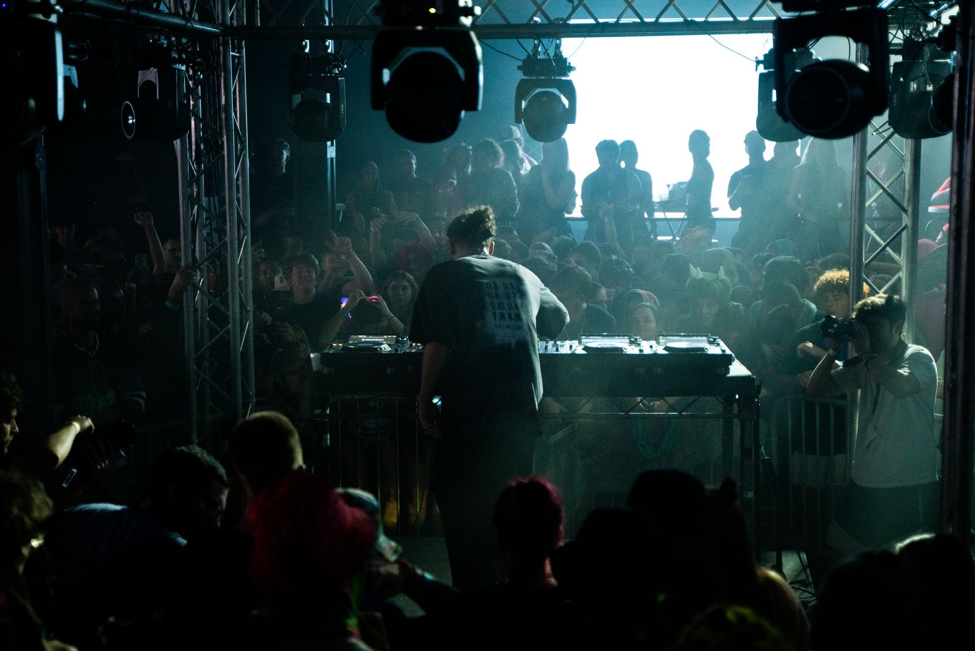 A man is playing a dj set in front of a crowd