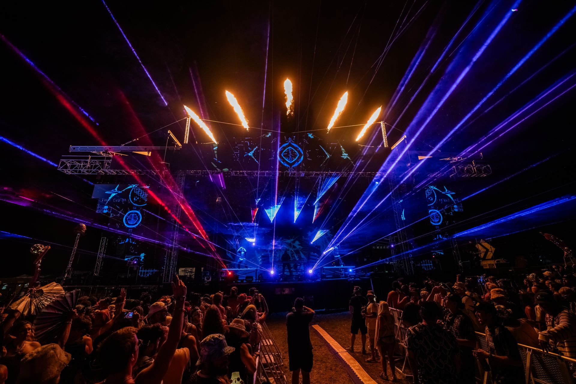A crowd of people are standing in front of a stage at a concert.