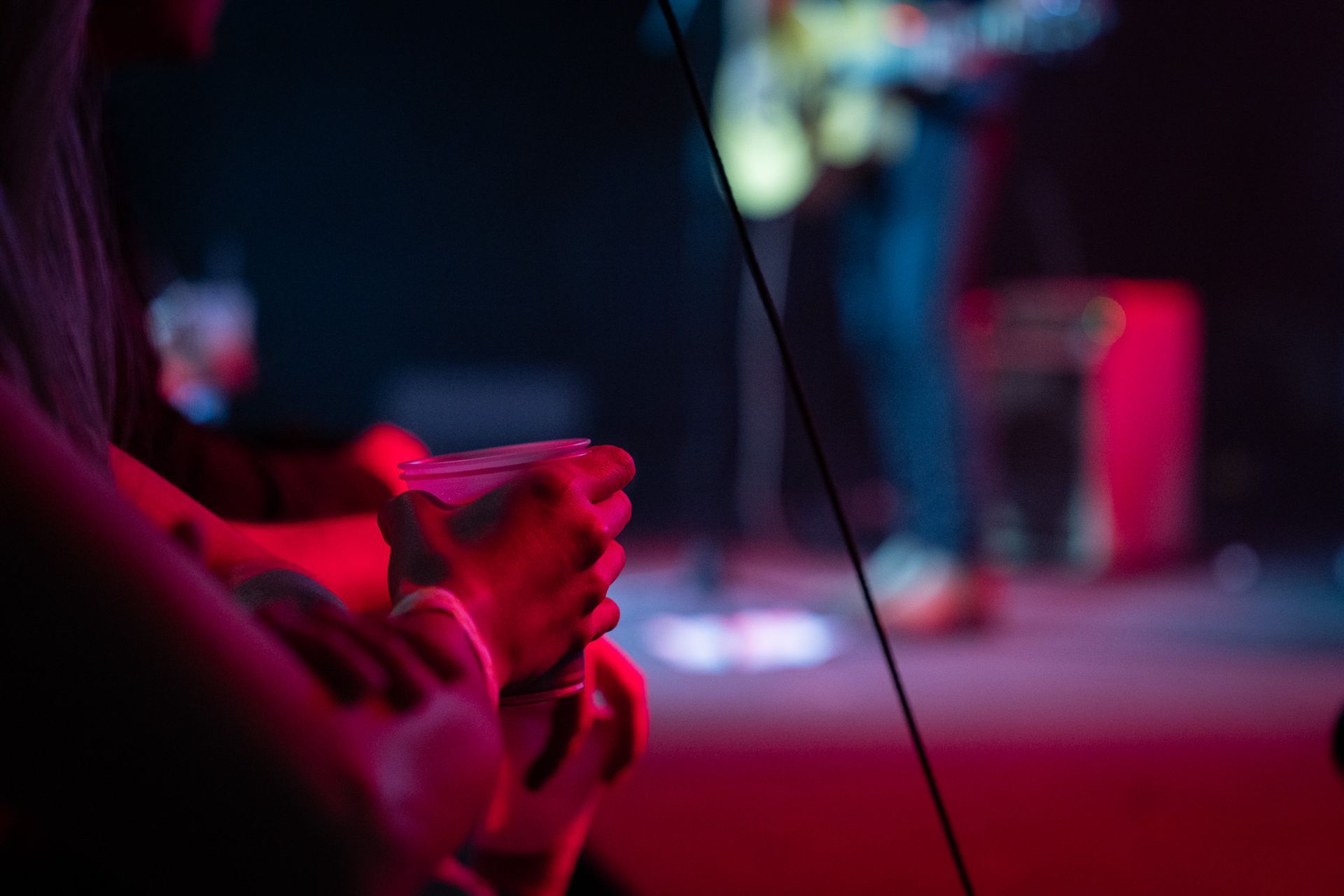 A person is playing a video game on a stage in a dark room.