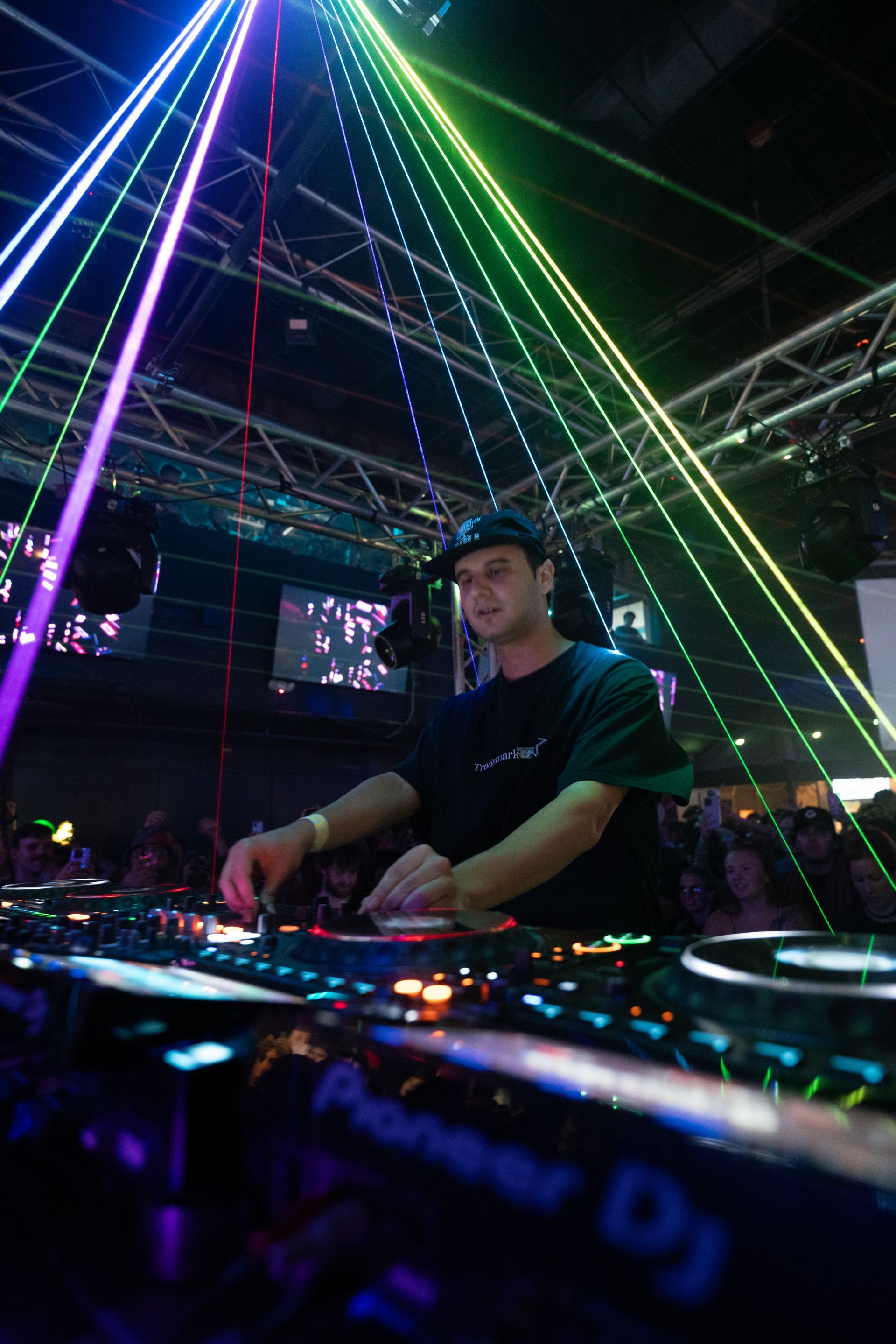 A man is playing a dj set in a dark room.