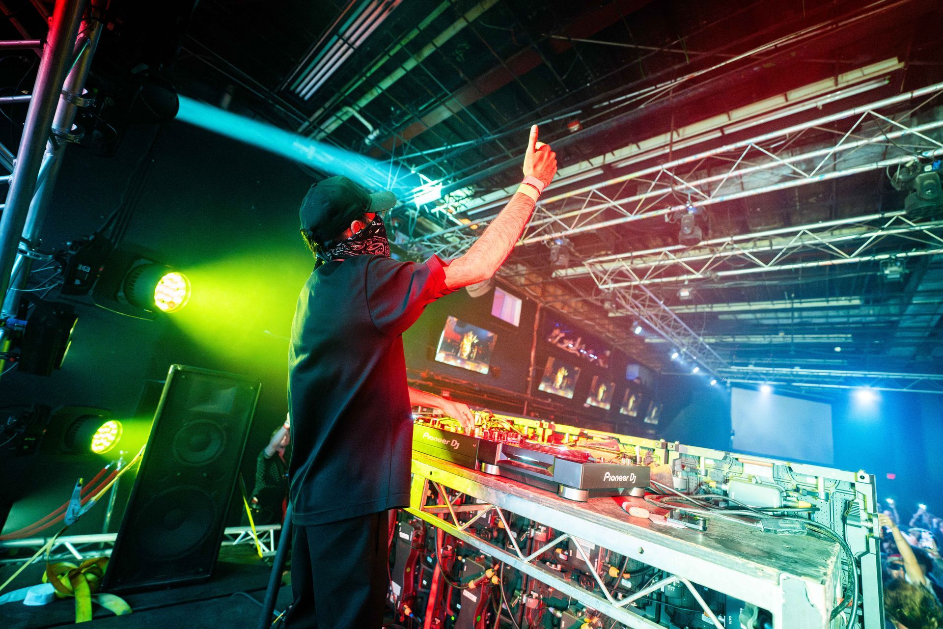 A man is standing on a stage with his arms in the air.