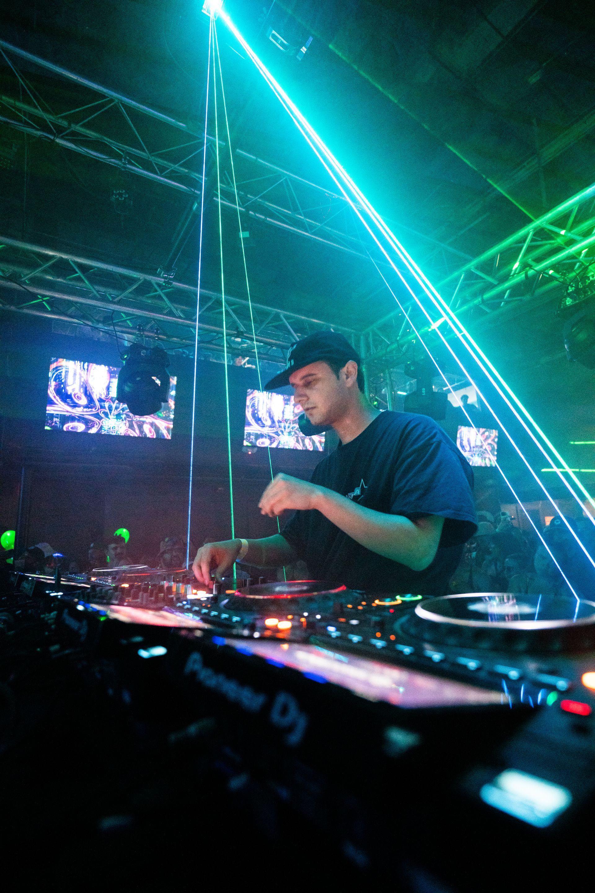 A man is playing a dj set in a dark room.