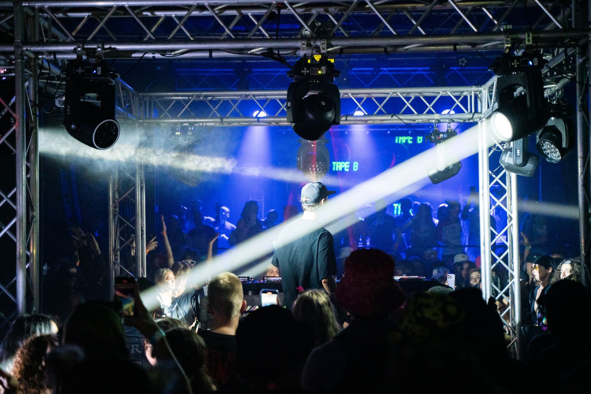 A man is standing in front of a crowd of people at a concert.