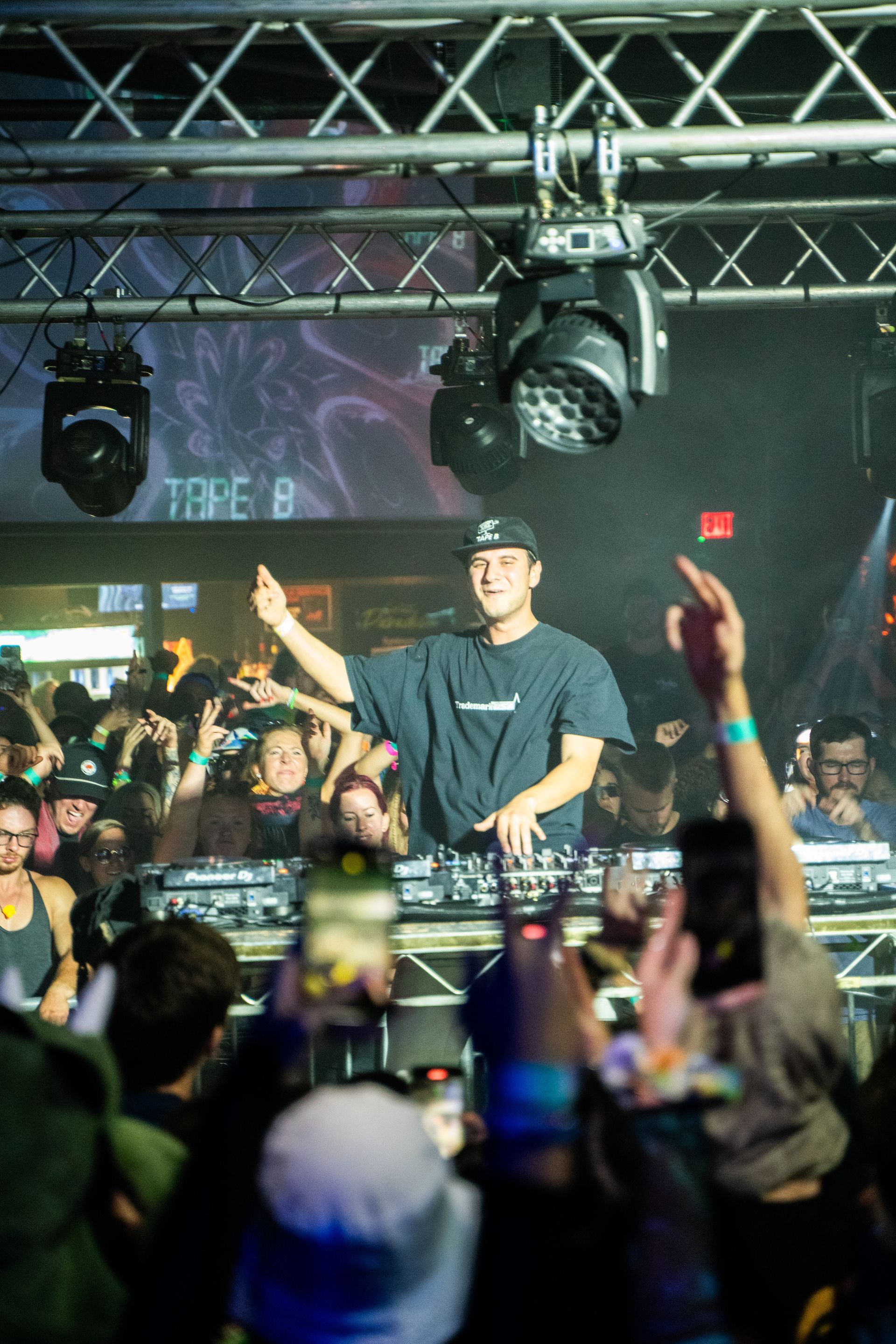 A man is playing a dj set in front of a crowd at a concert.