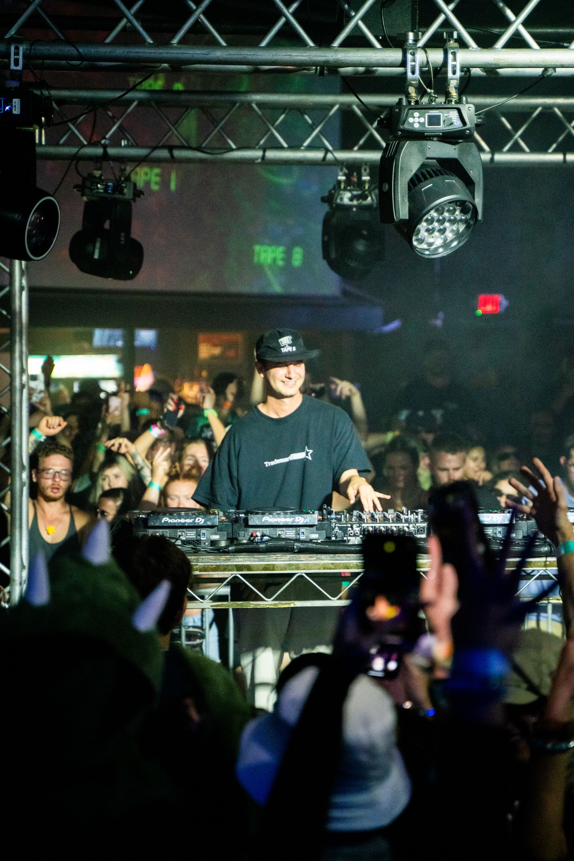 A man is playing a dj set in front of a crowd of people.