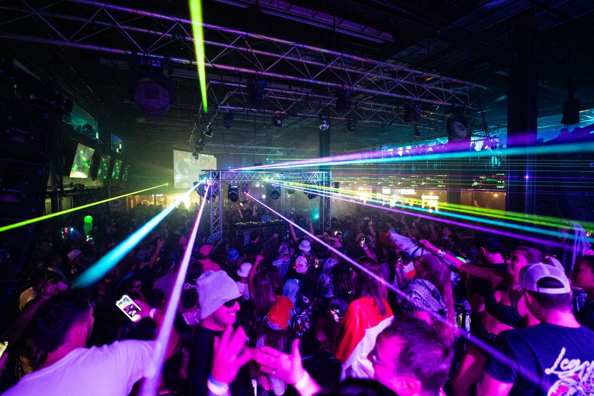 A crowd of people are dancing in a club with a lot of lights