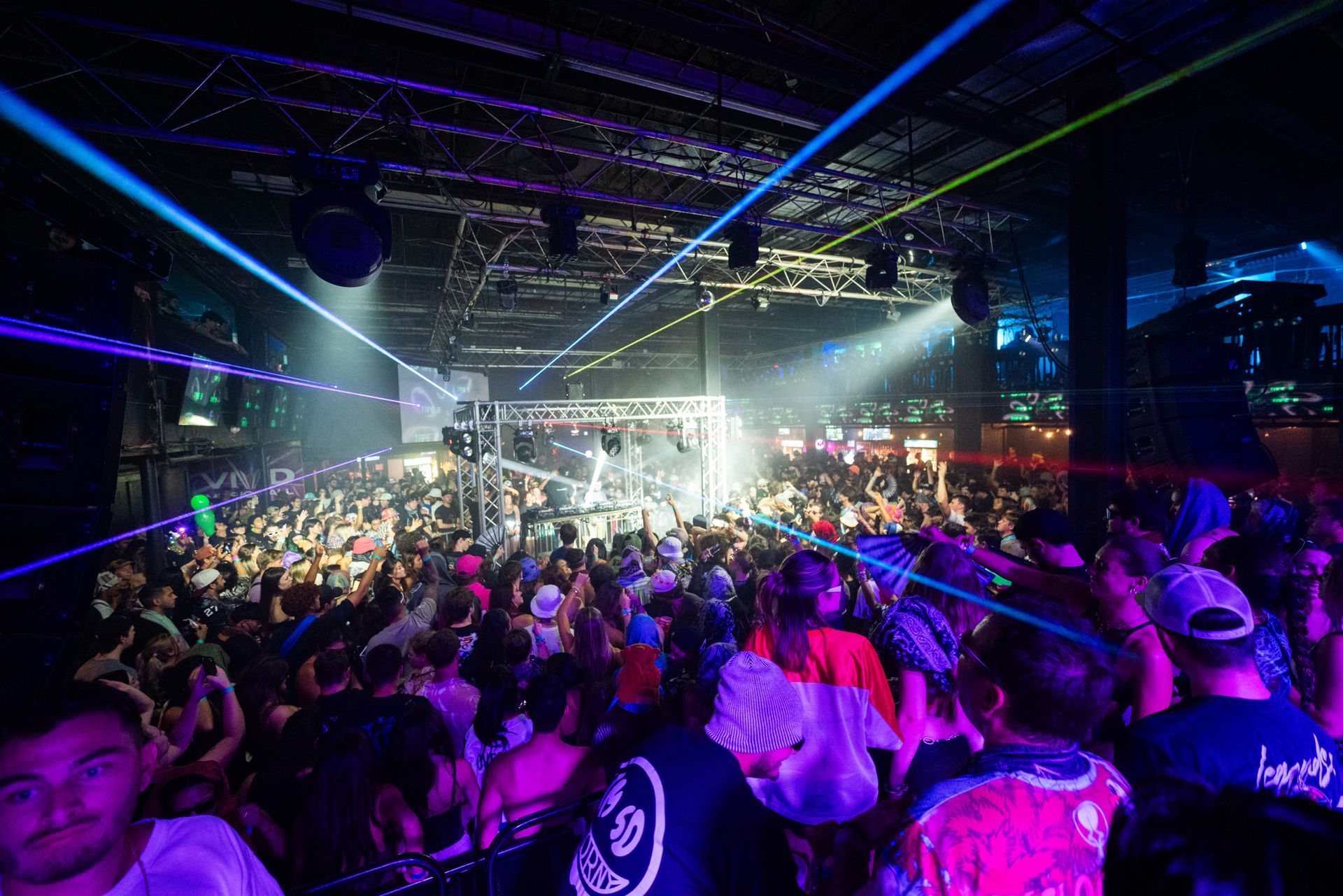 A large crowd of people are dancing in a club.