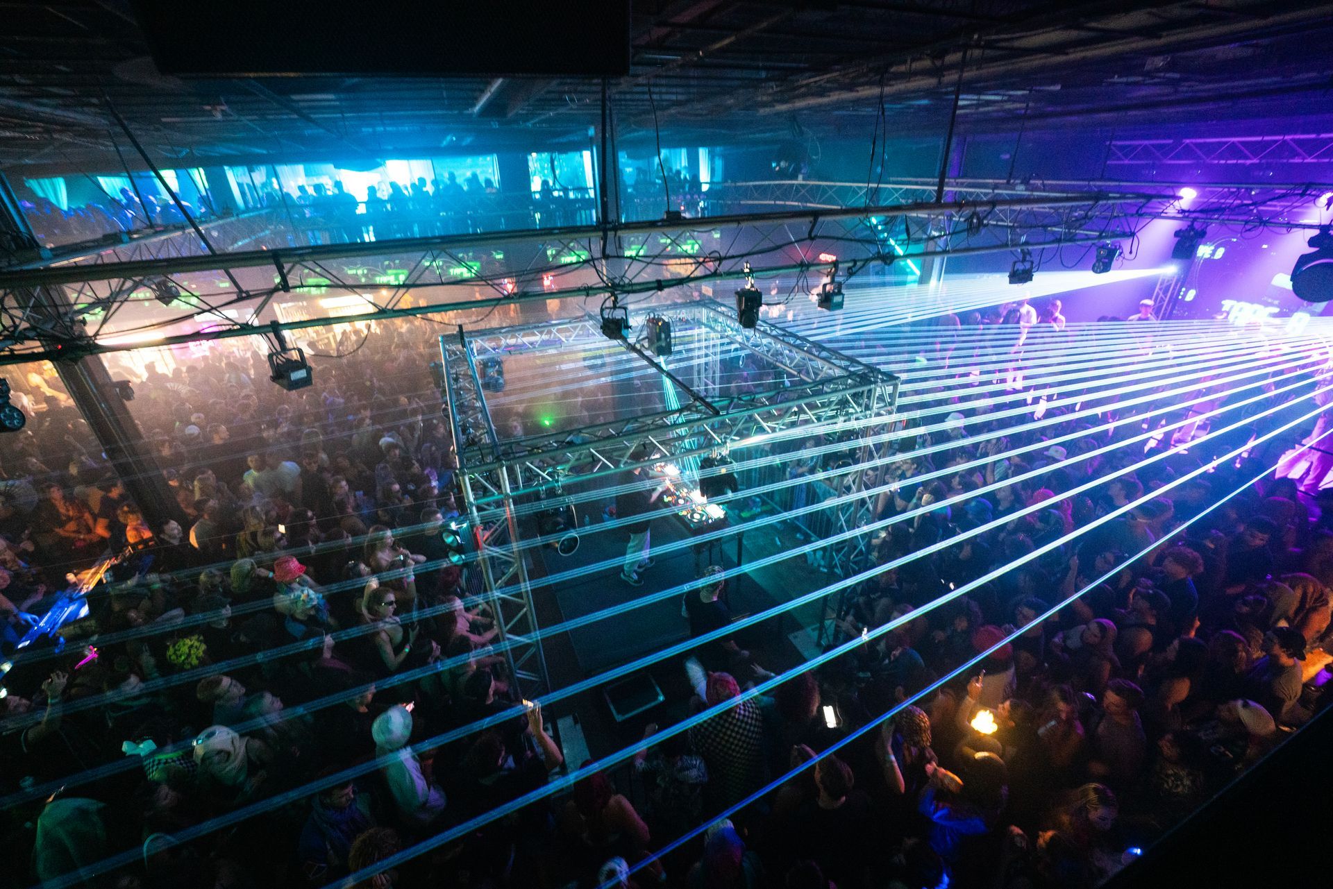 A large crowd of people are dancing in a club.