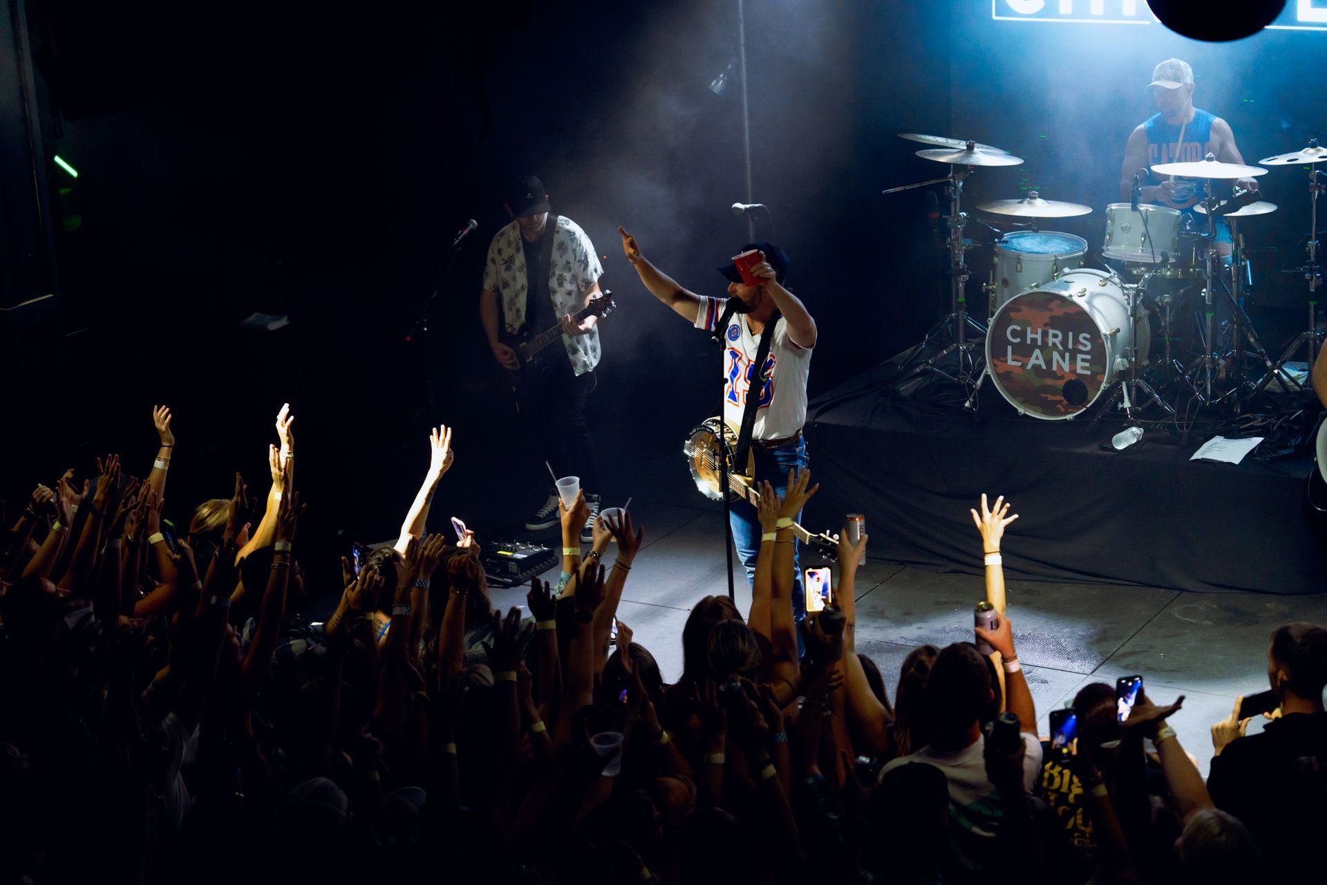 A man is singing into a microphone on a stage in front of a crowd.