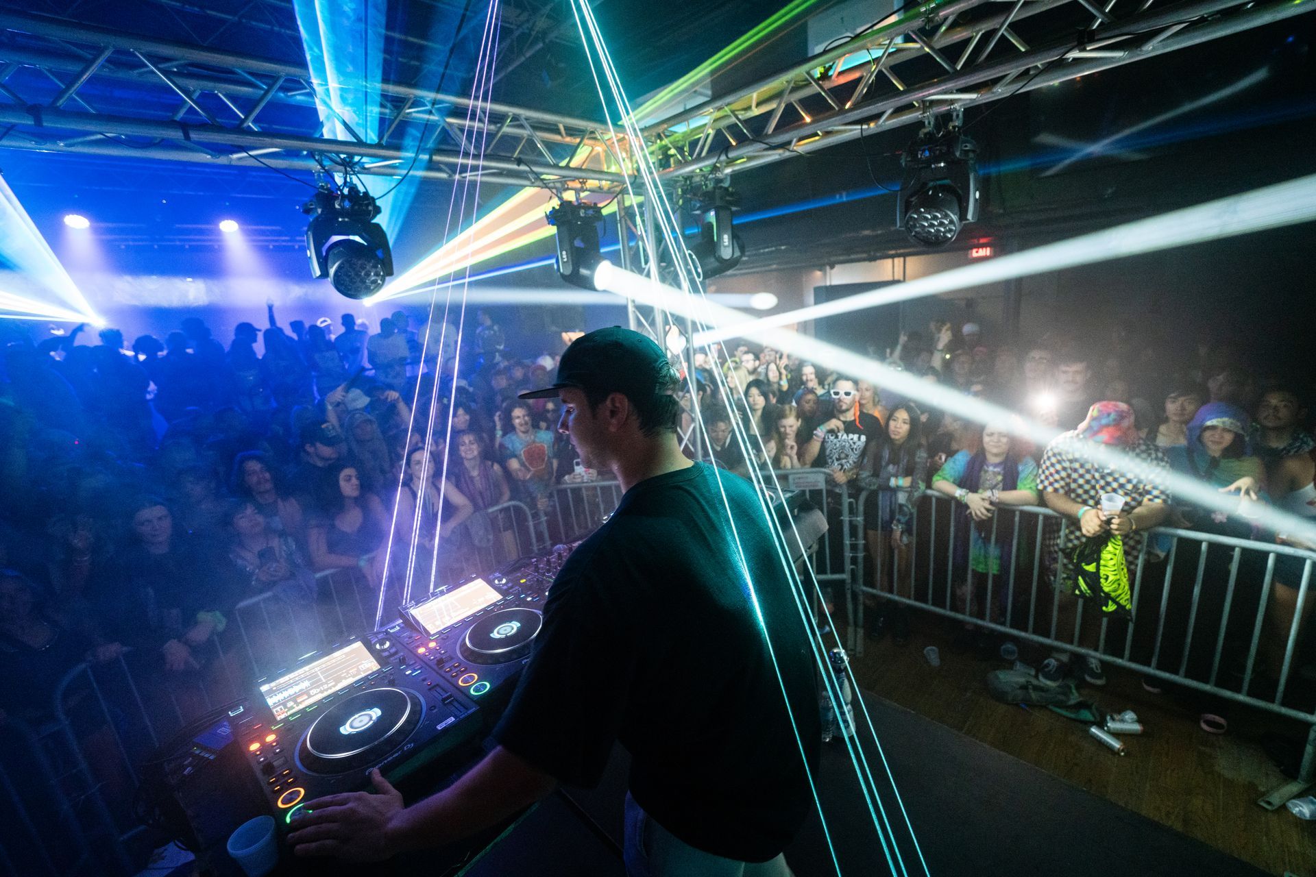 A man is playing a dj set in front of a crowd at a concert.