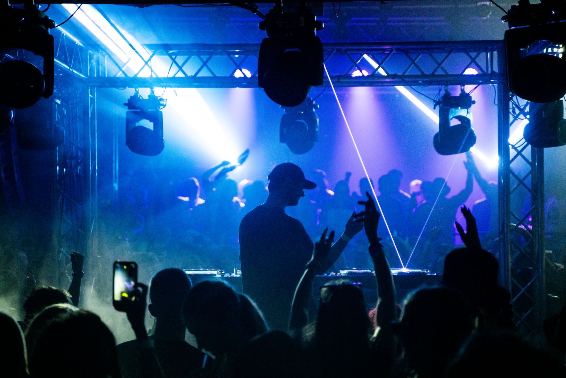 A man is playing a dj set in front of a crowd at a concert.