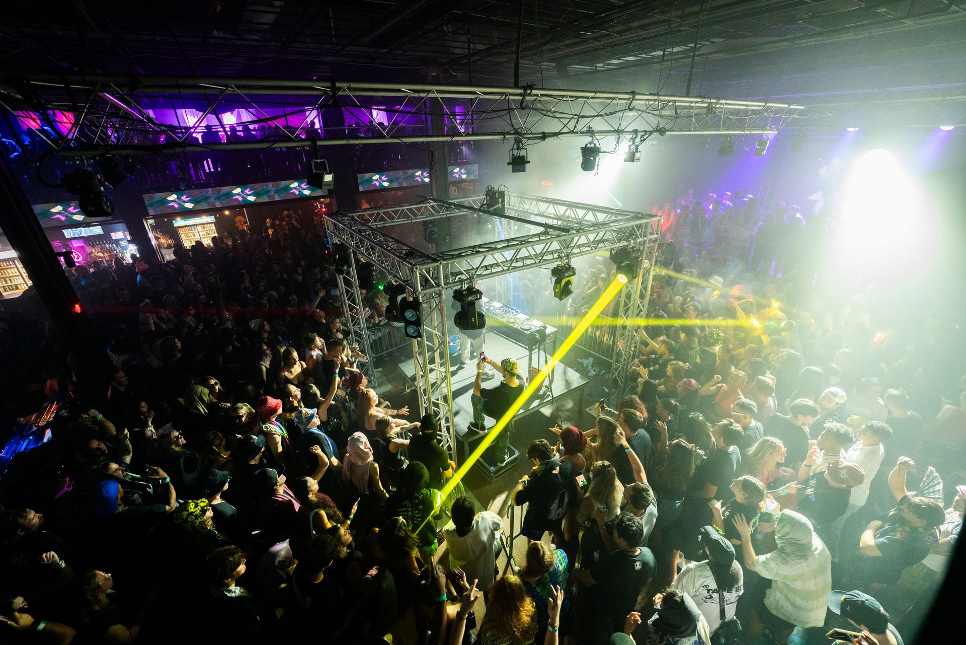 A large crowd of people are dancing in a club.