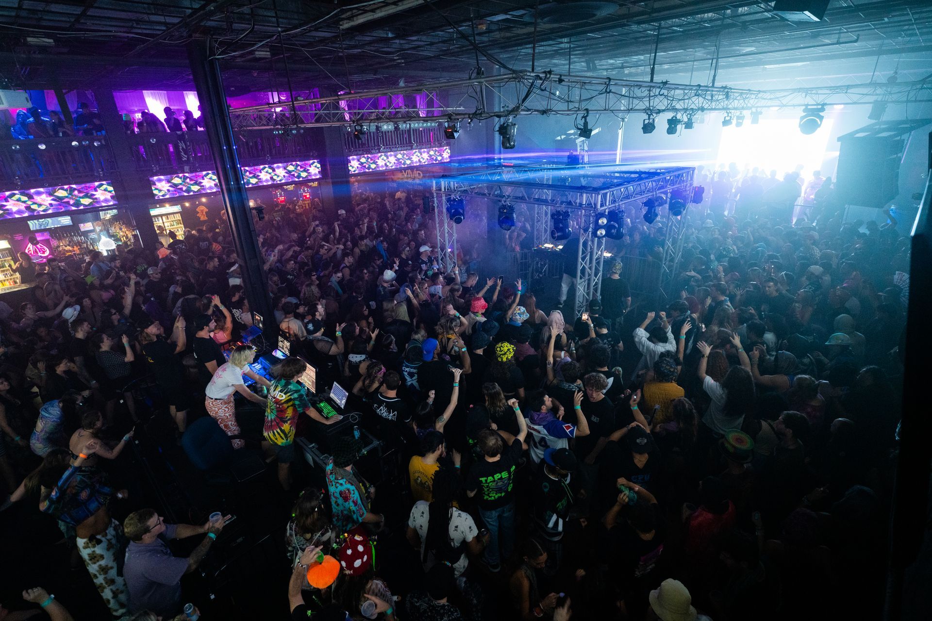 A large crowd of people are dancing in a club.