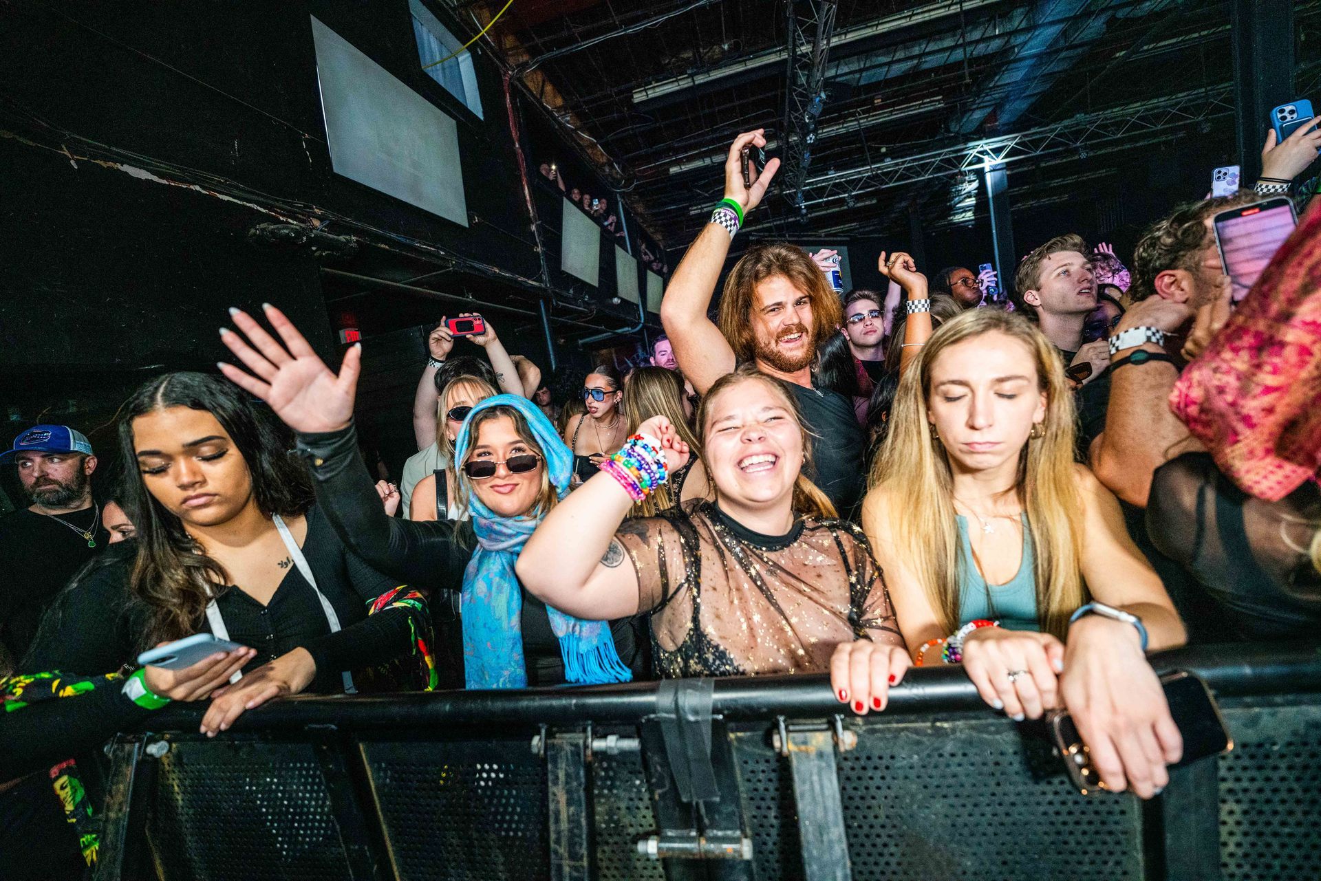 A group of people are standing in a crowd at a concert.