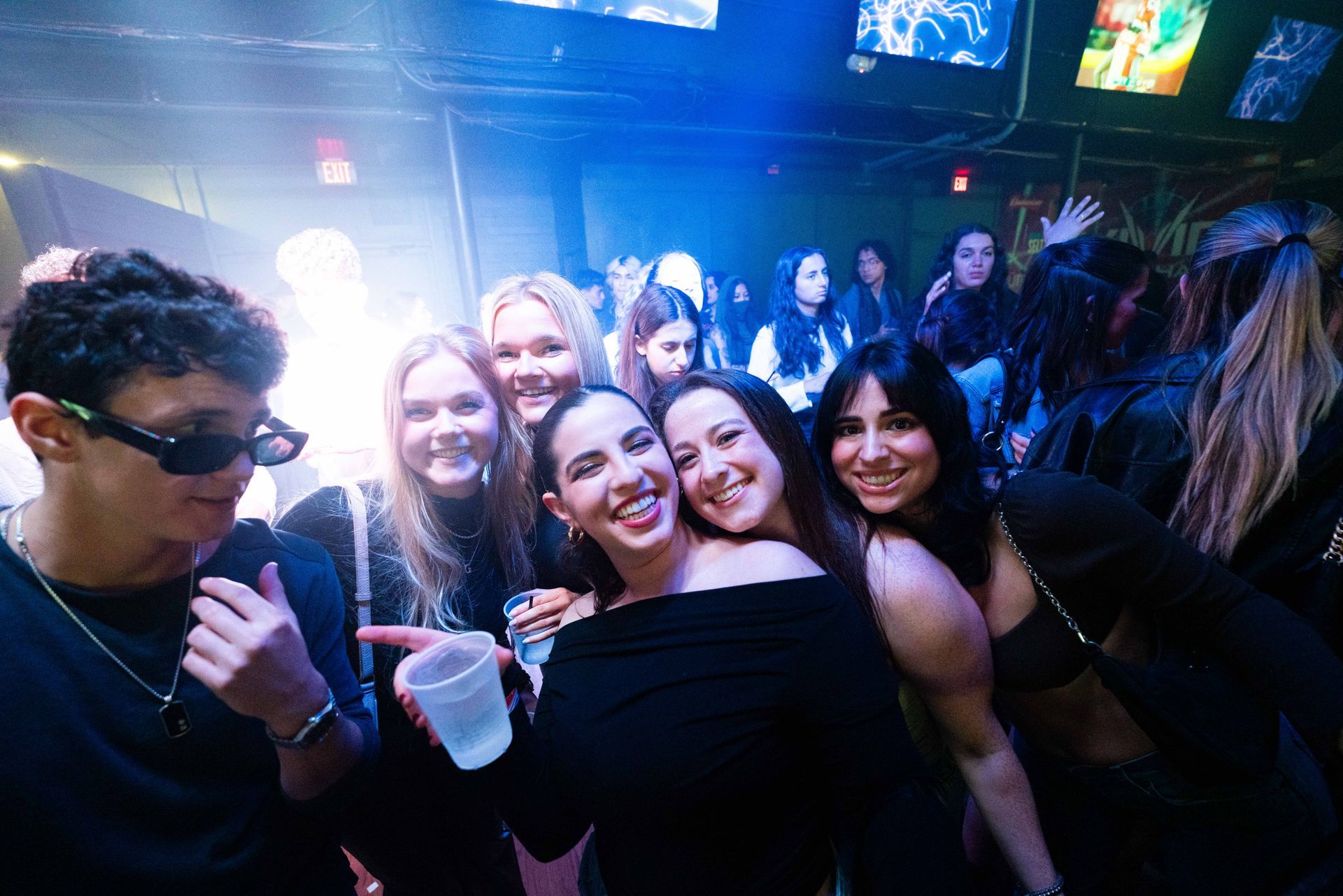A group of people are posing for a picture in a club.