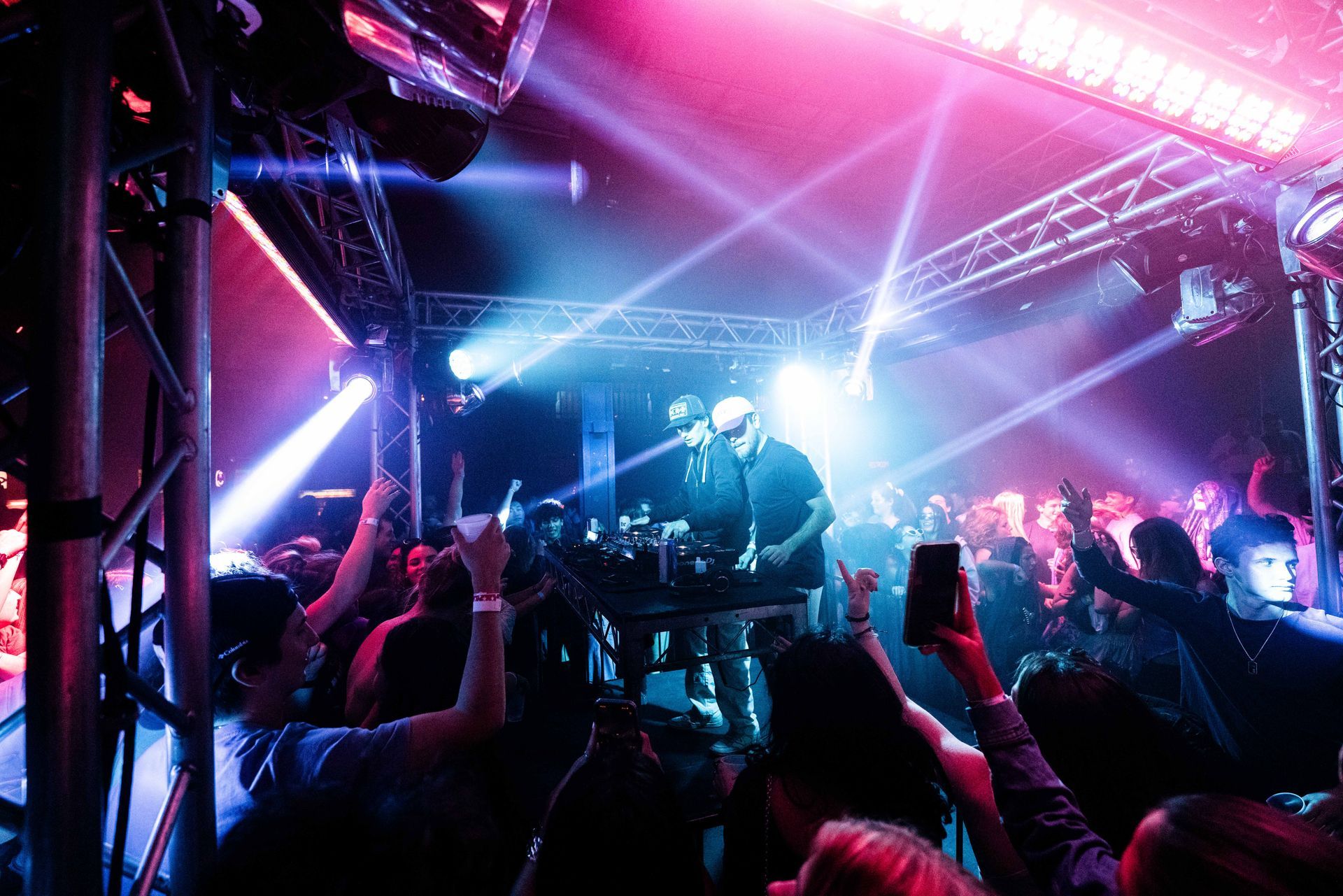 A group of people are standing in front of a stage at a concert.