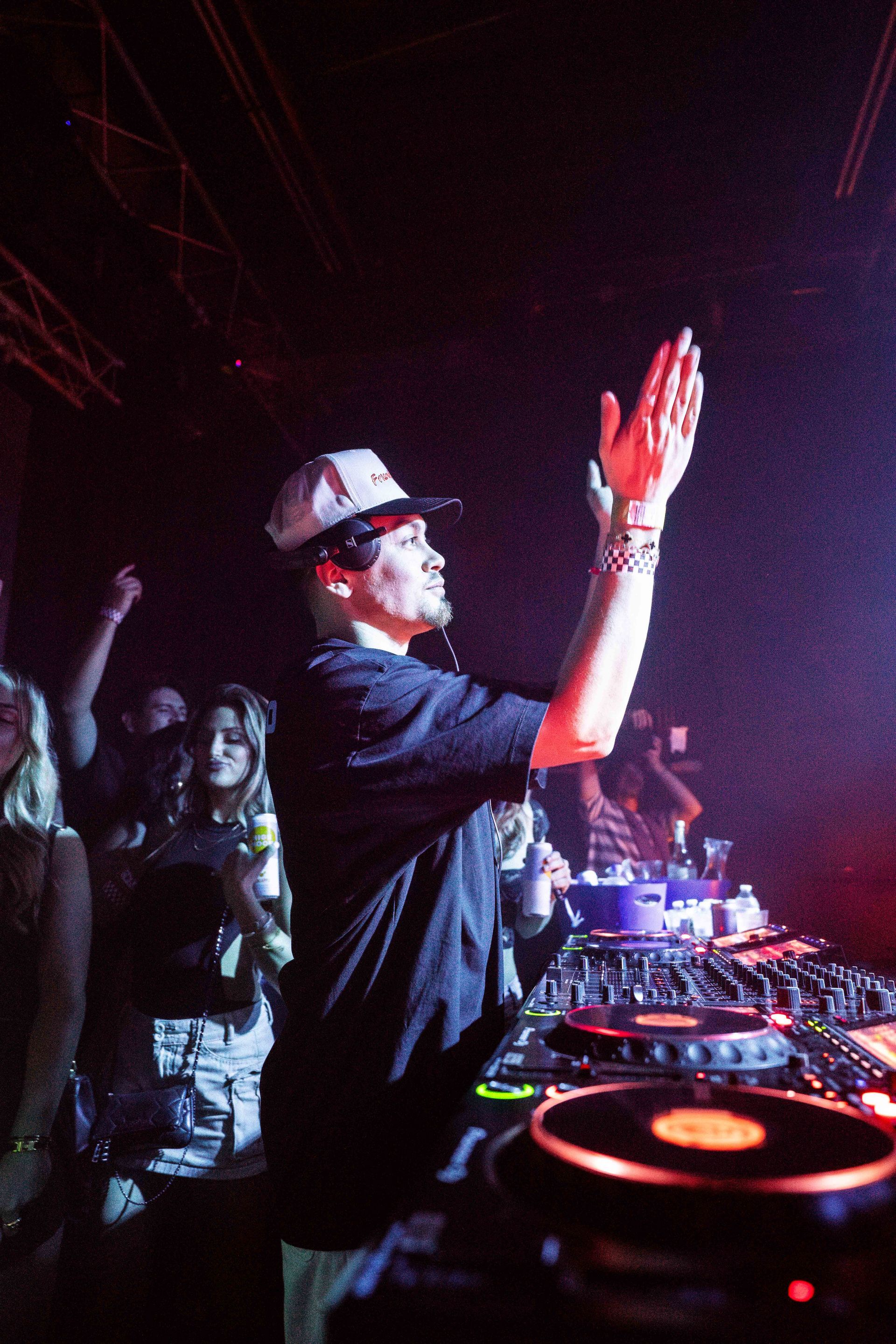 A man in a hat is standing in front of a crowd at a concert.