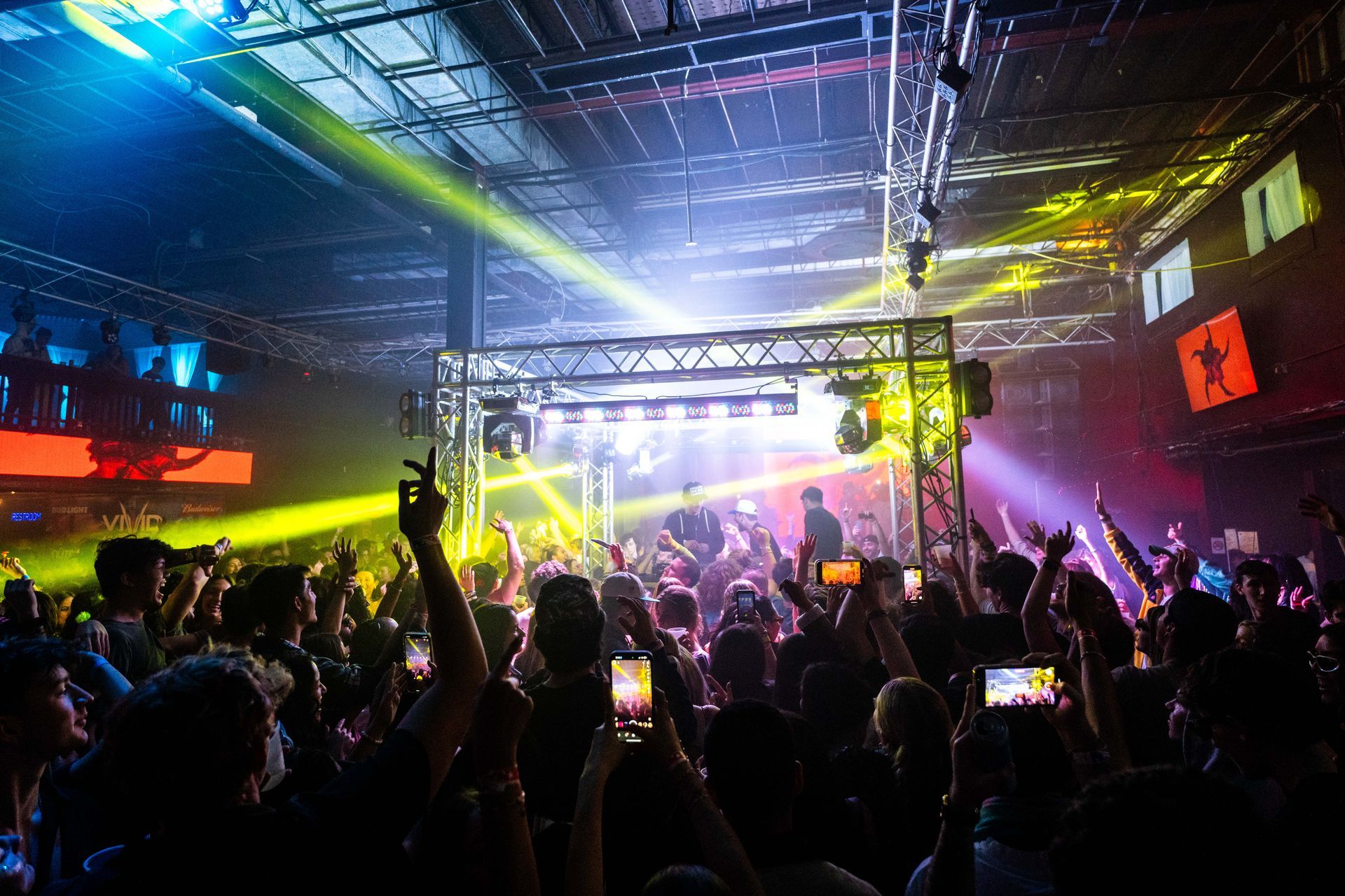 A crowd of people are standing in front of a stage at a concert.