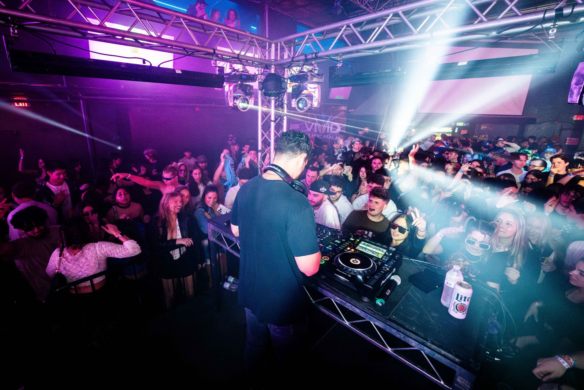 A dj is playing music in front of a crowd at a party.