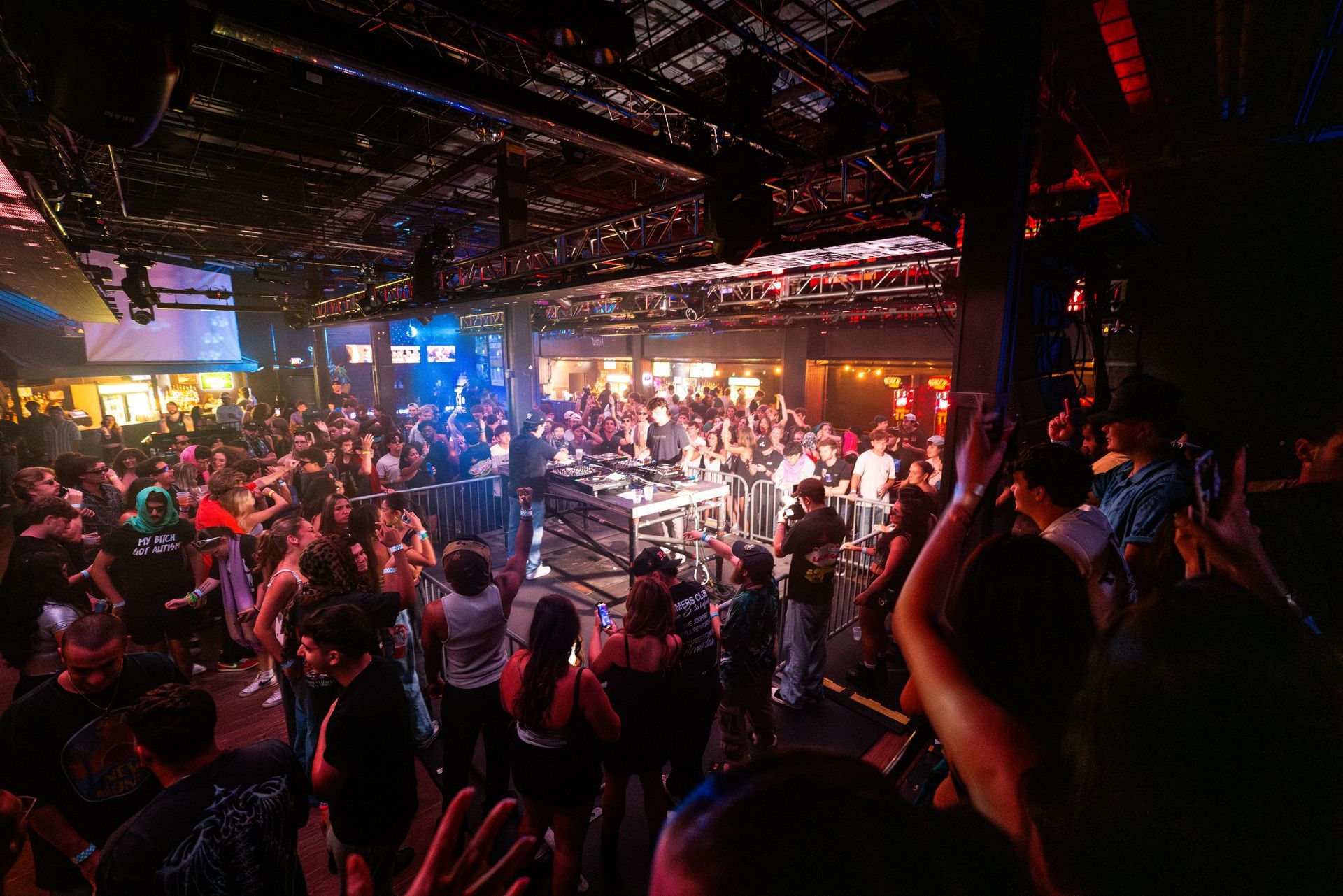 A large crowd of people are dancing in a club.