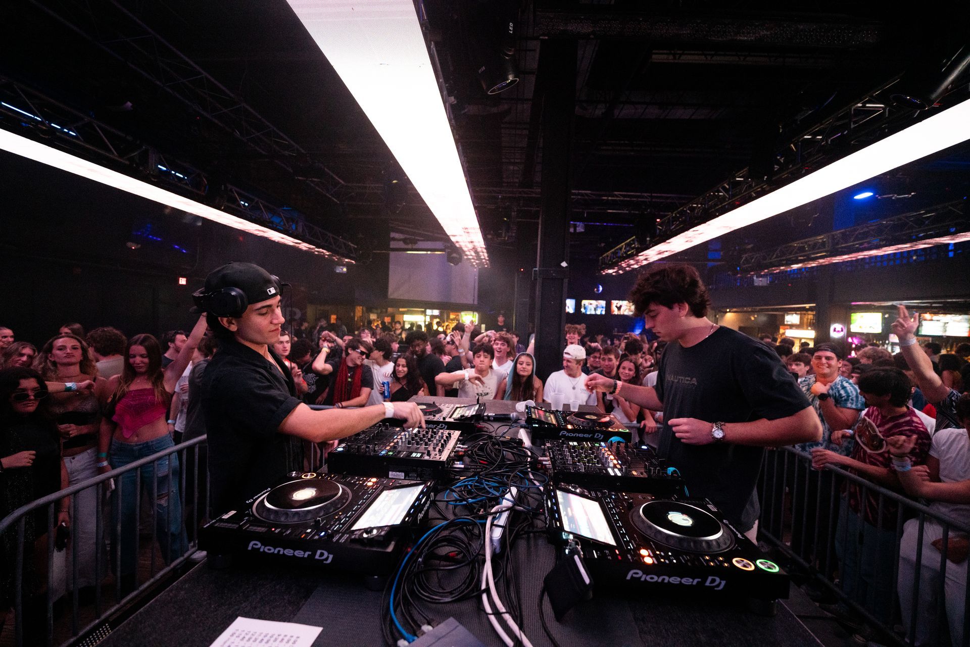 Two men are playing music on a stage in front of a crowd.