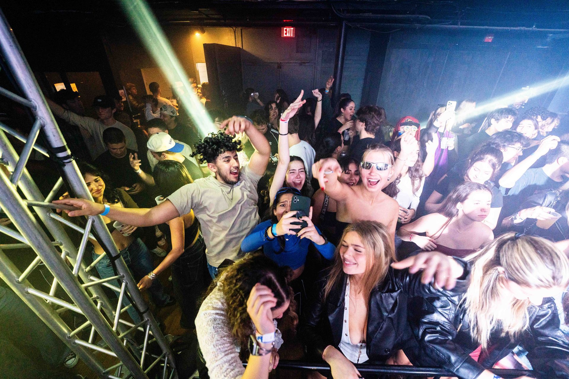 A crowd of people are dancing in a club.