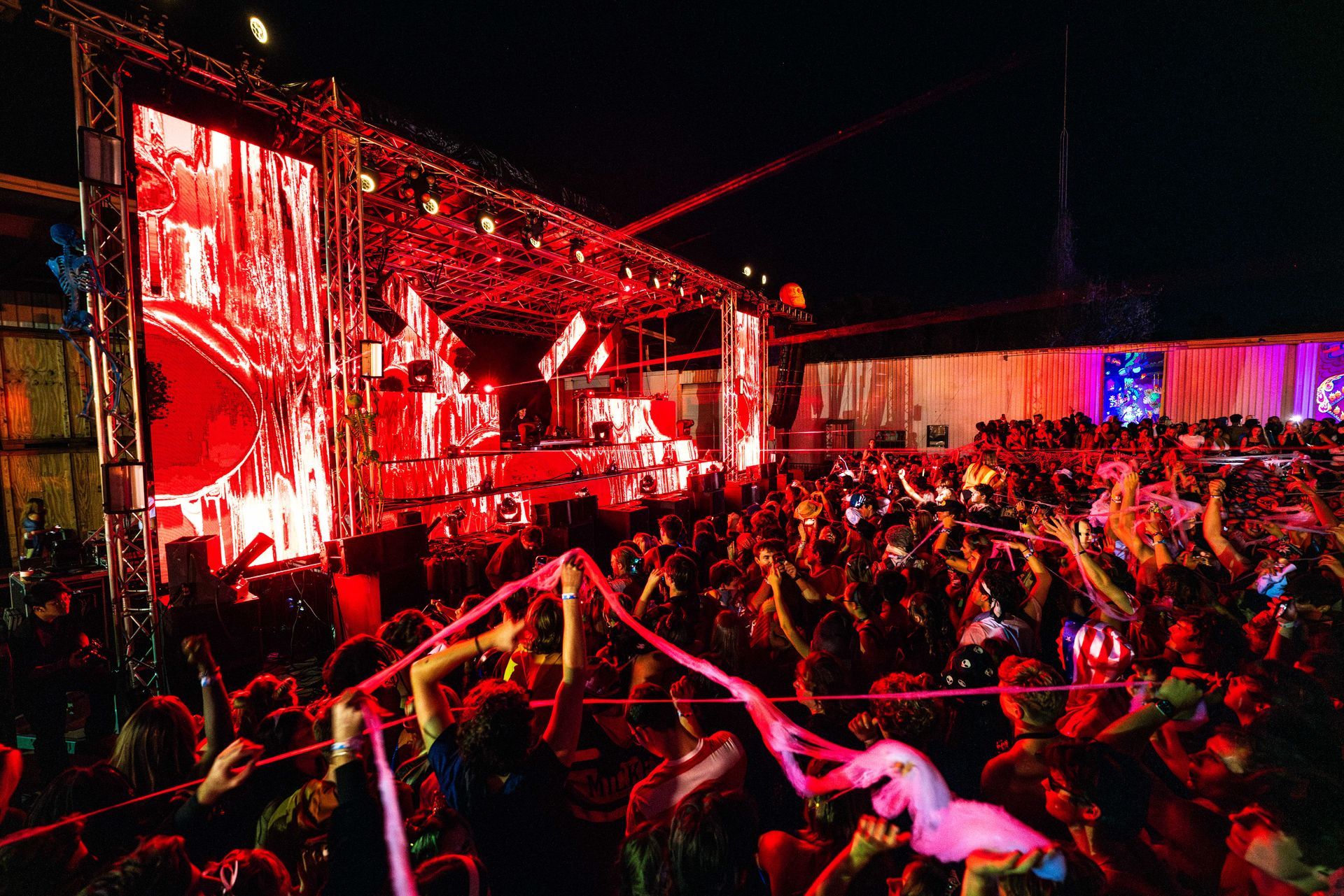 A crowd of people are standing in front of a stage at a concert.