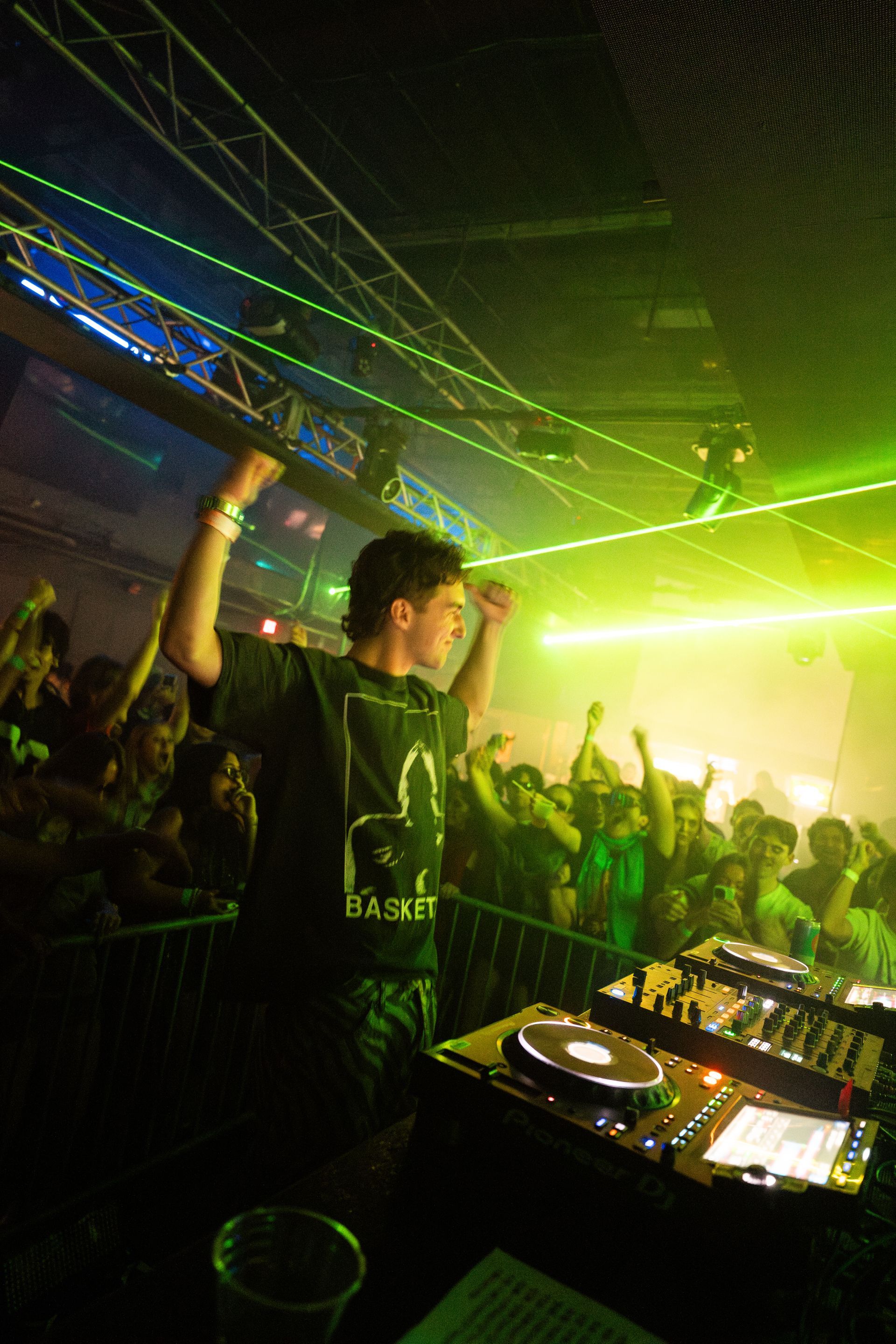 A dj is playing music in front of a crowd at a party.