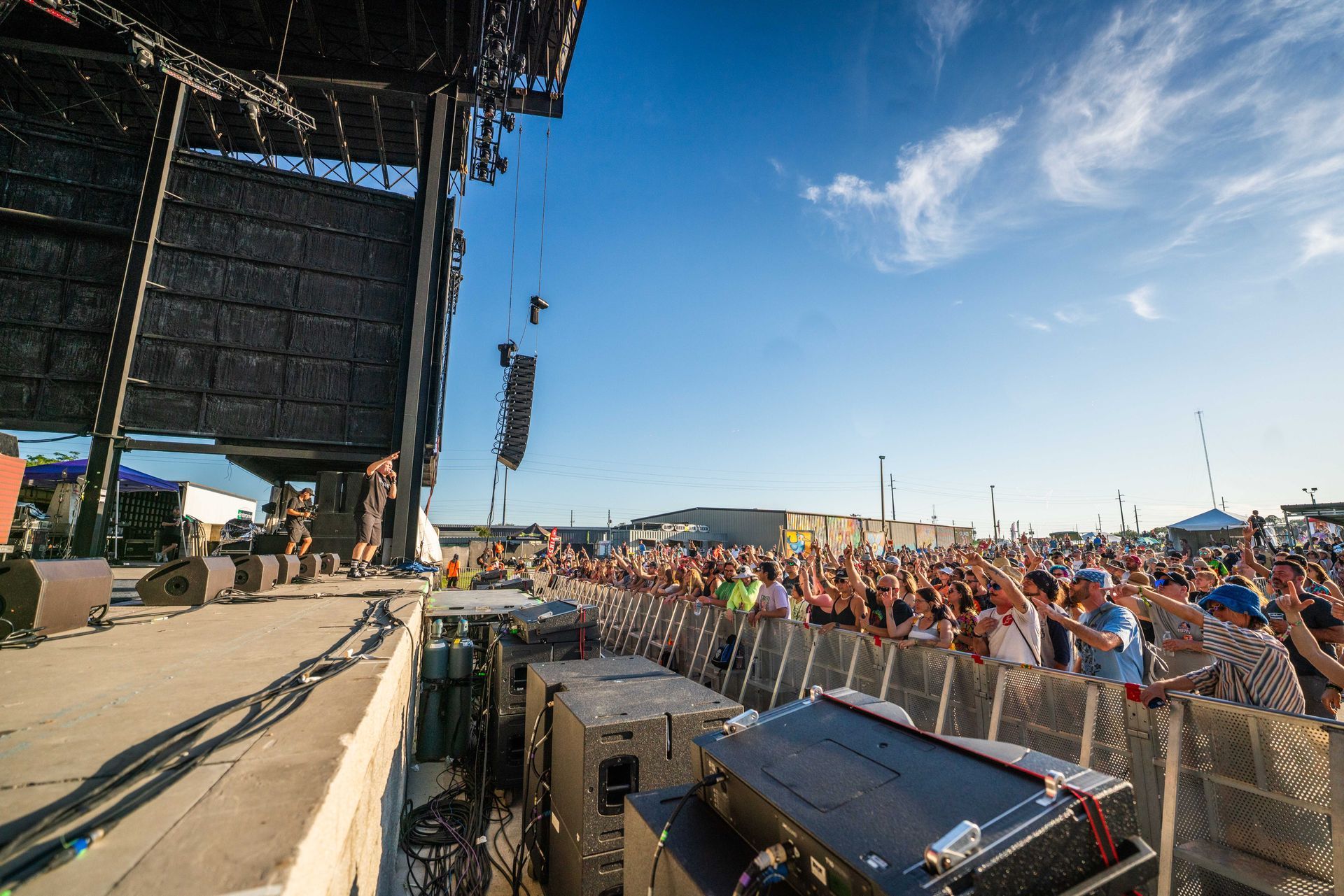 A crowd of people are standing in front of a stage at a concert.