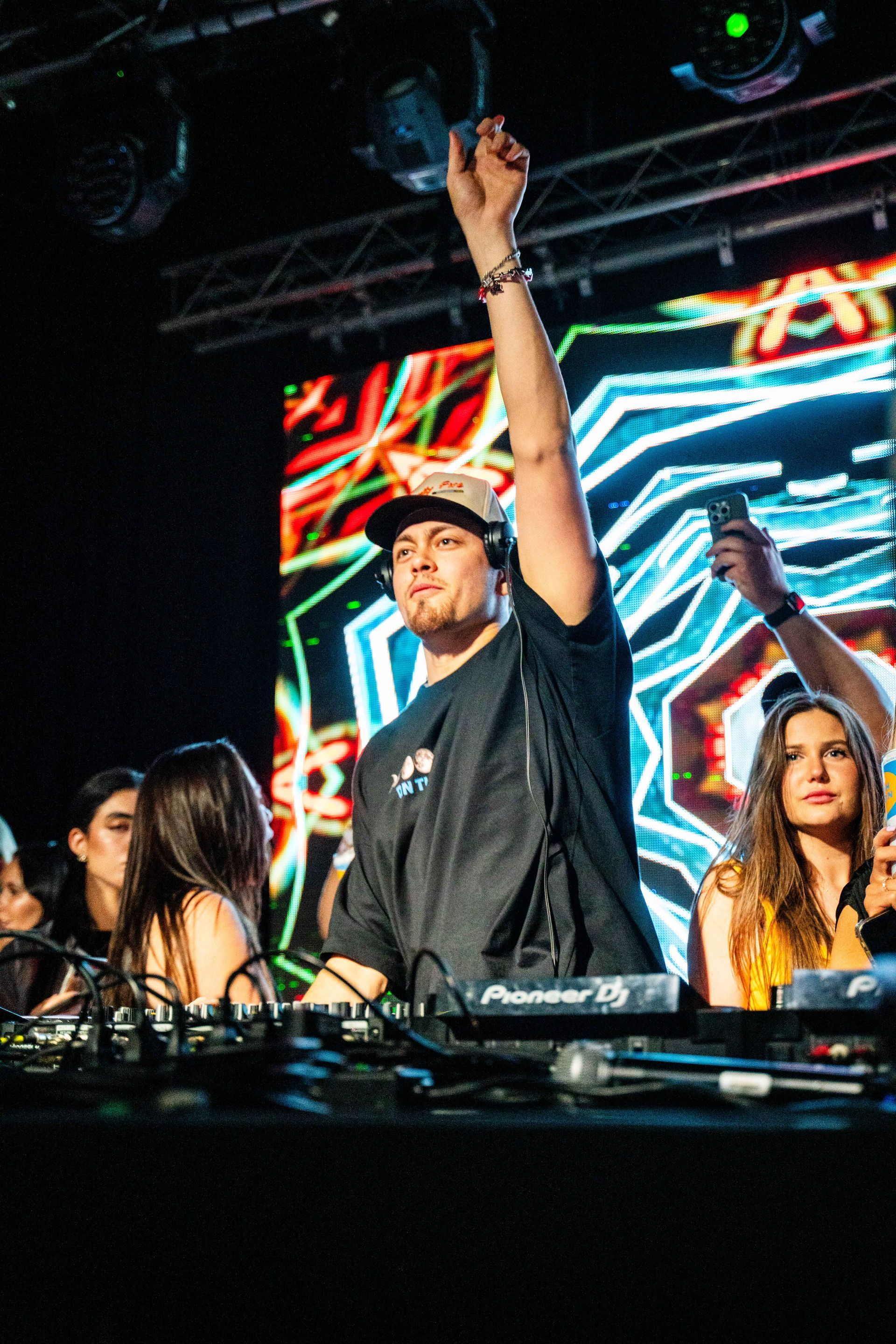 A man is standing on a stage with his hand in the air.