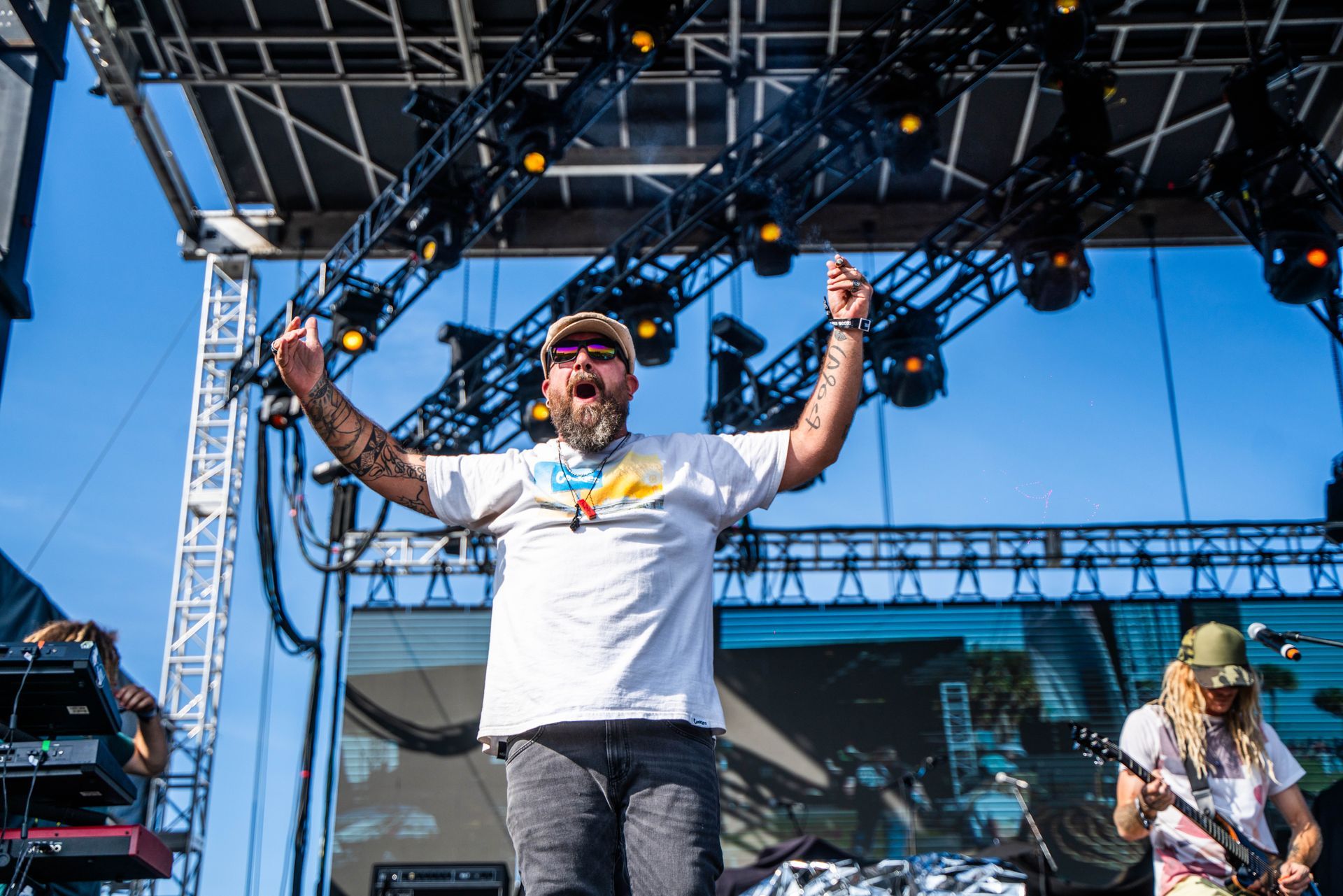 A man with a beard is standing on a stage with his arms in the air.