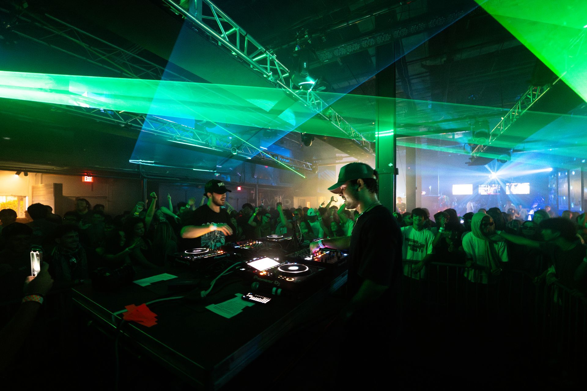 A dj is playing music in front of a crowd at a party.