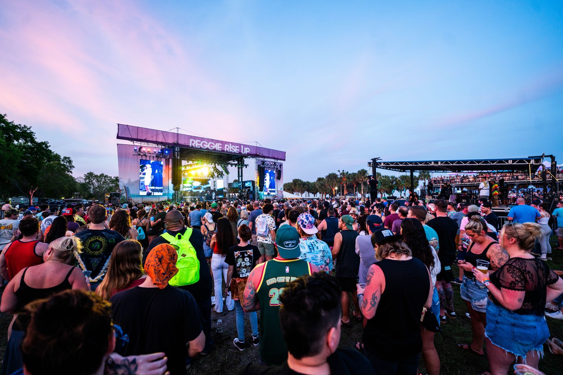 A crowd of people are standing in front of a stage at a concert.