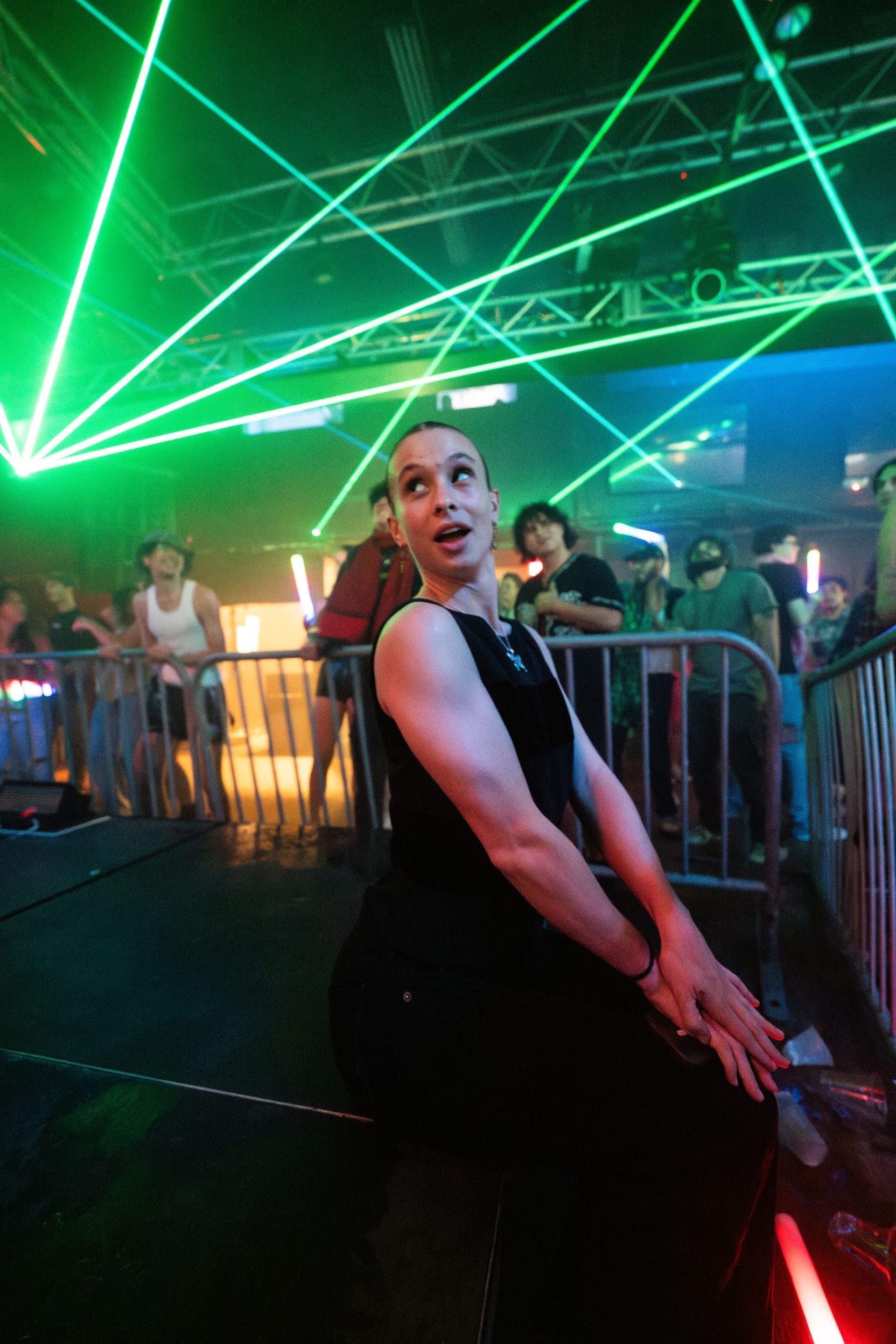 A man in a black dress is sitting in front of a crowd at a party.