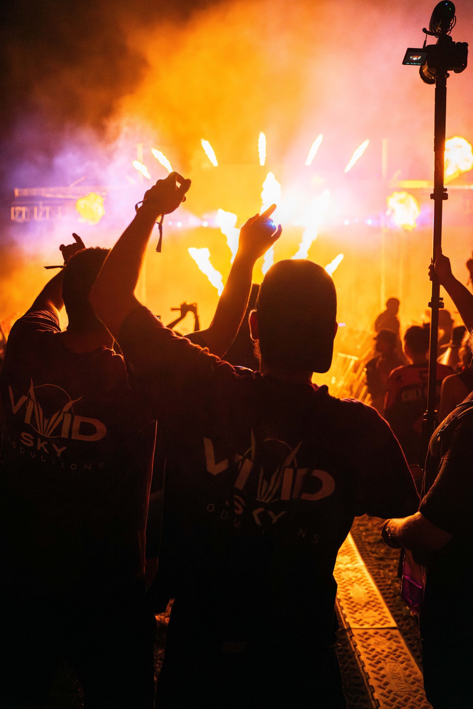 A group of people are standing in front of a fireworks display.