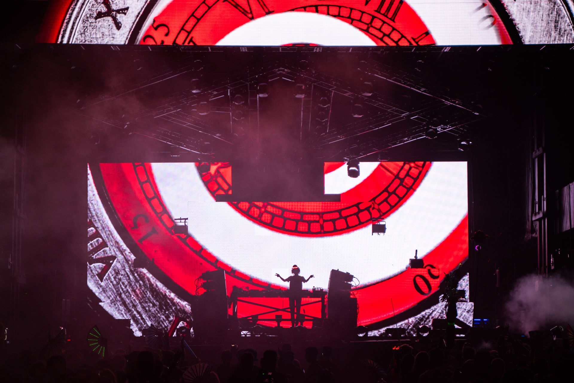 A man is standing in front of a large screen with a target on it.