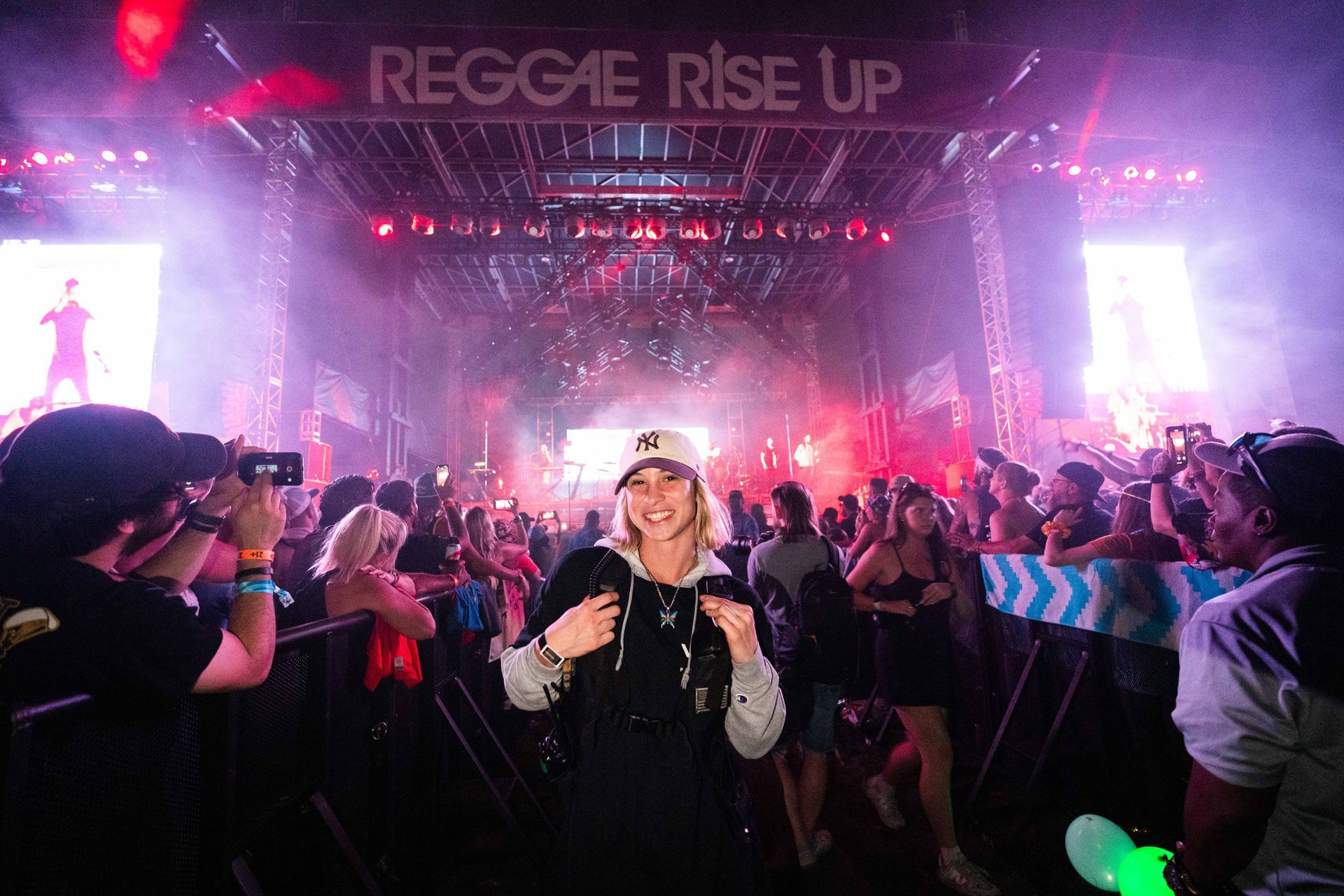 A woman is taking a picture of a crowd at a concert.