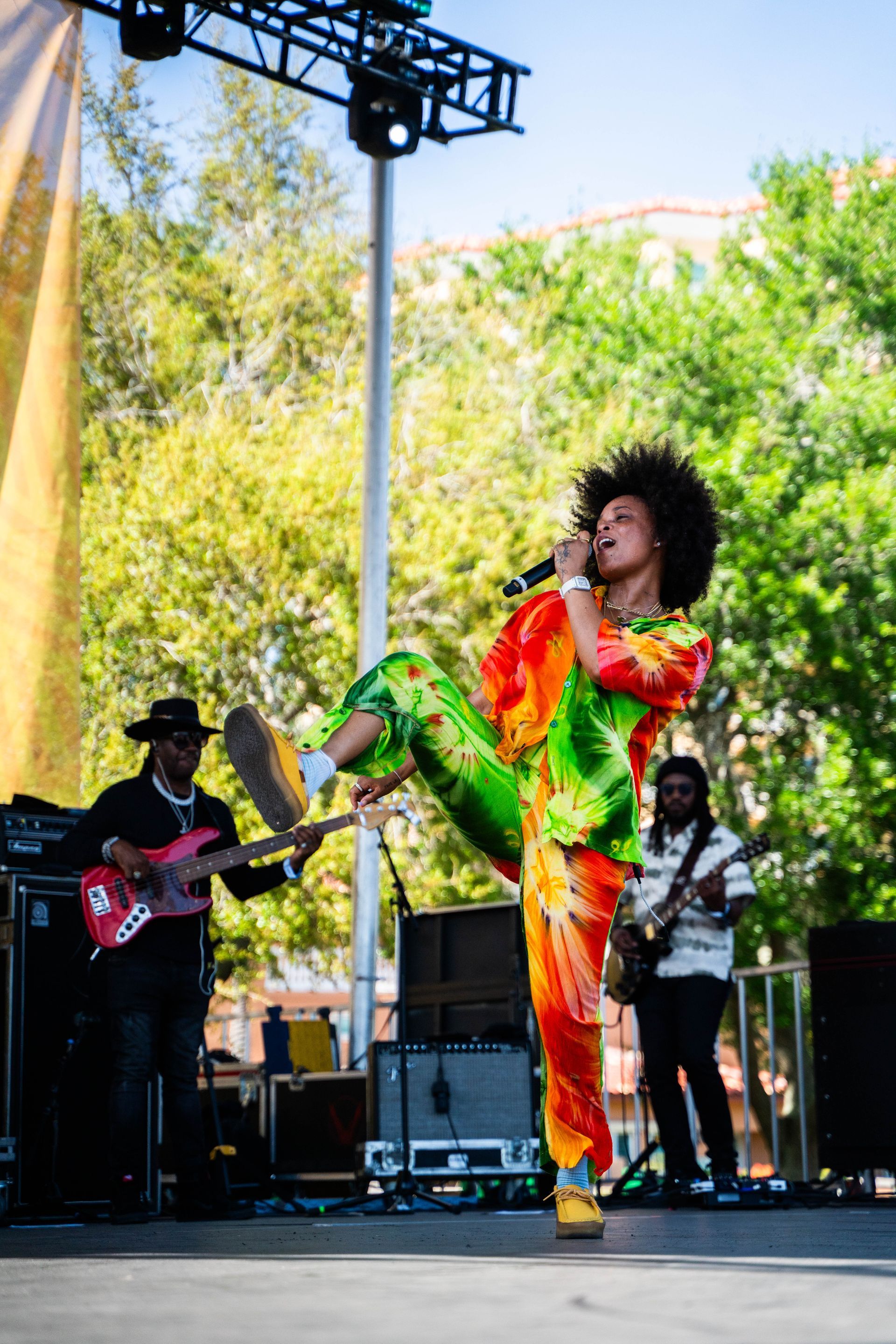 A man in a colorful outfit is singing into a microphone on a stage.